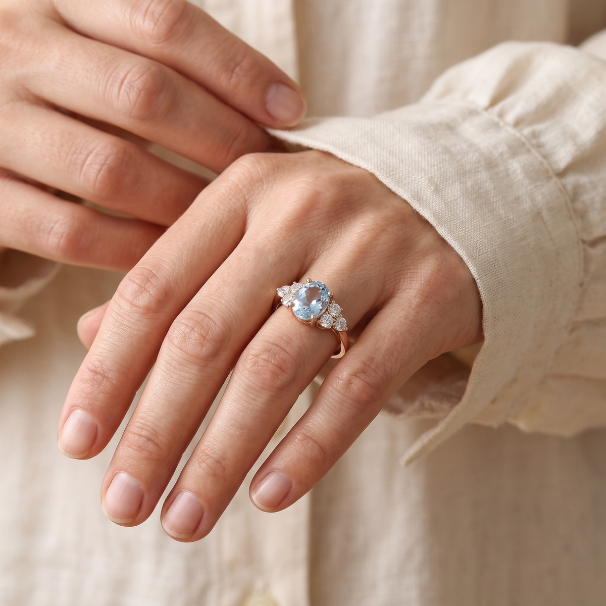 The Fiorella rose gold blue oval cluster ring worn by a model, cuff detail