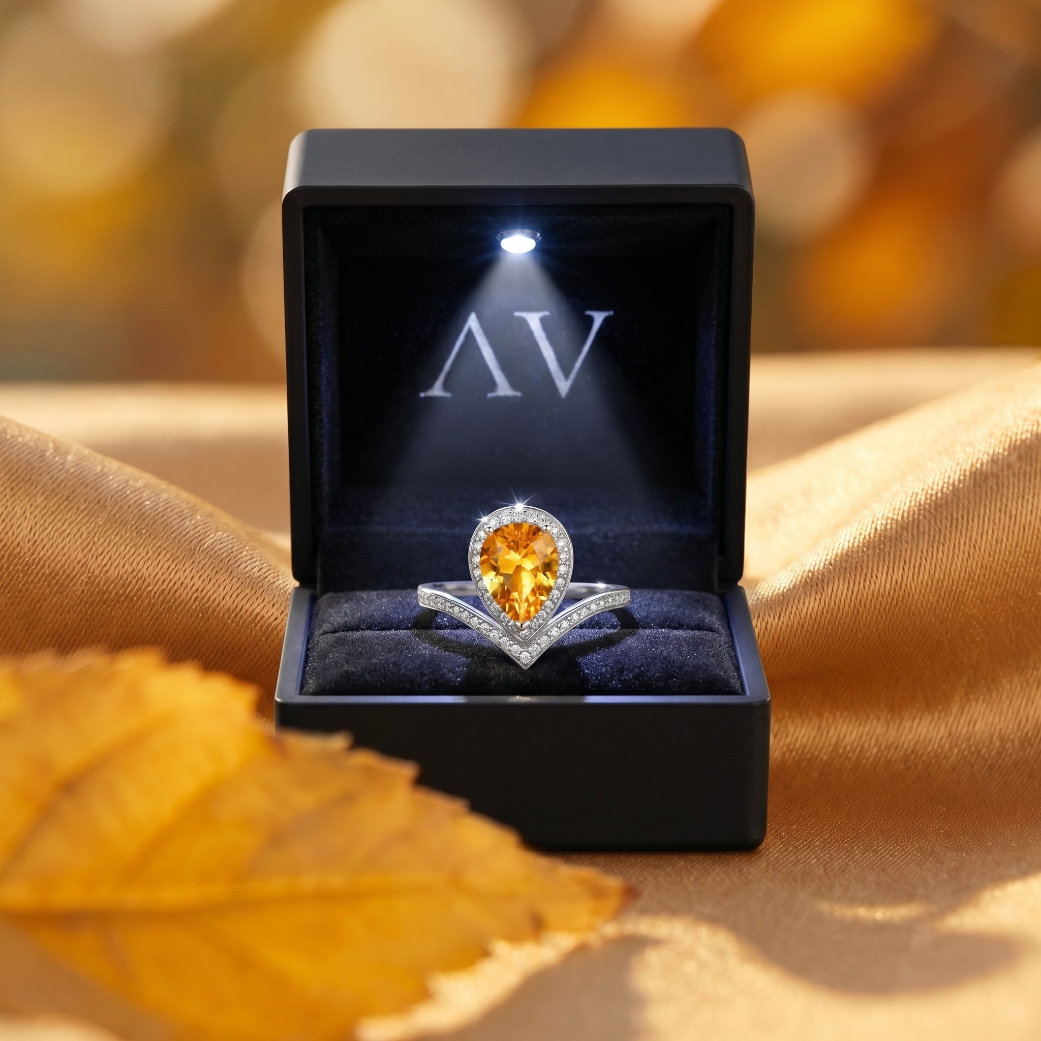 Pear cut natural citrine sterling silver ring presented in a lighted black velvet jewelry box.