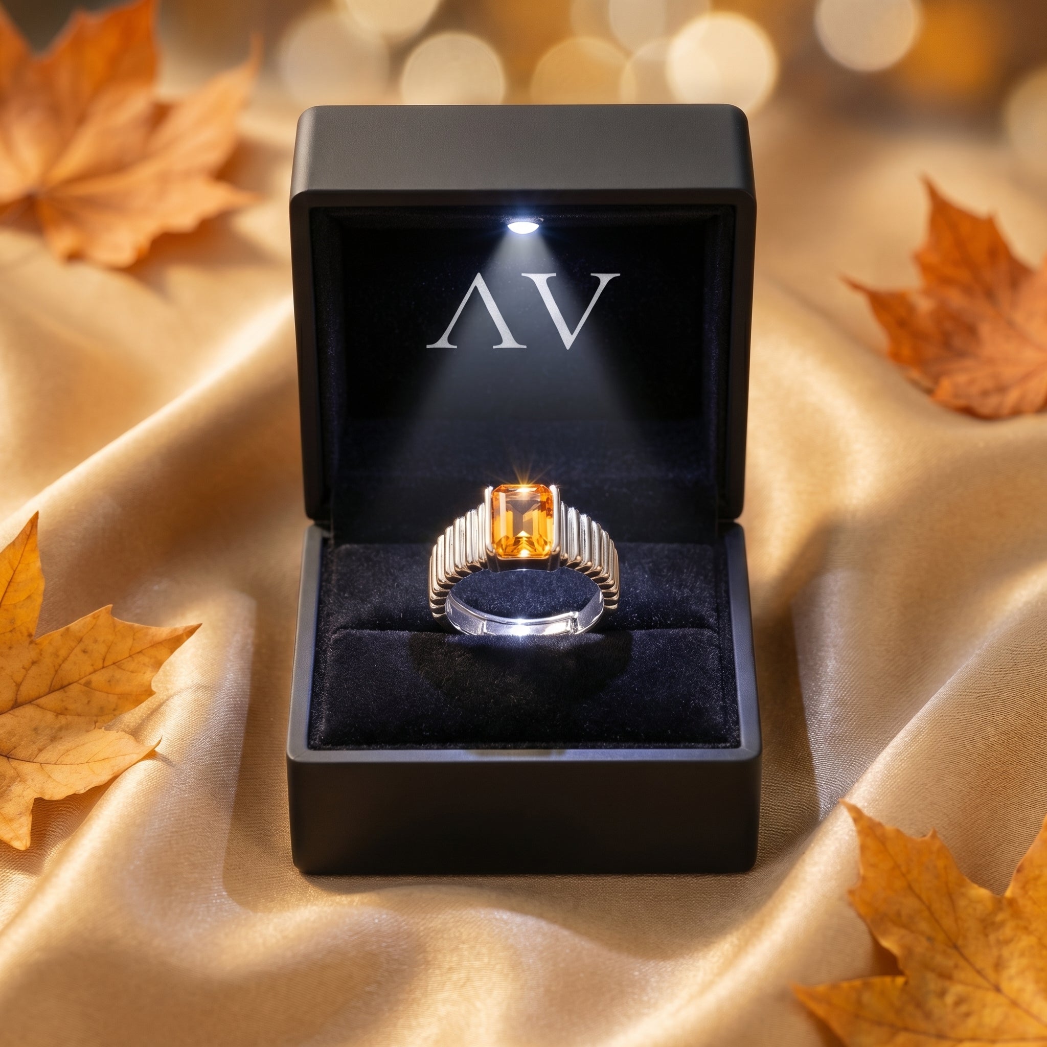Natural citrine silver ring presented in a black LED-lit gift box on gold fabric with leaves.