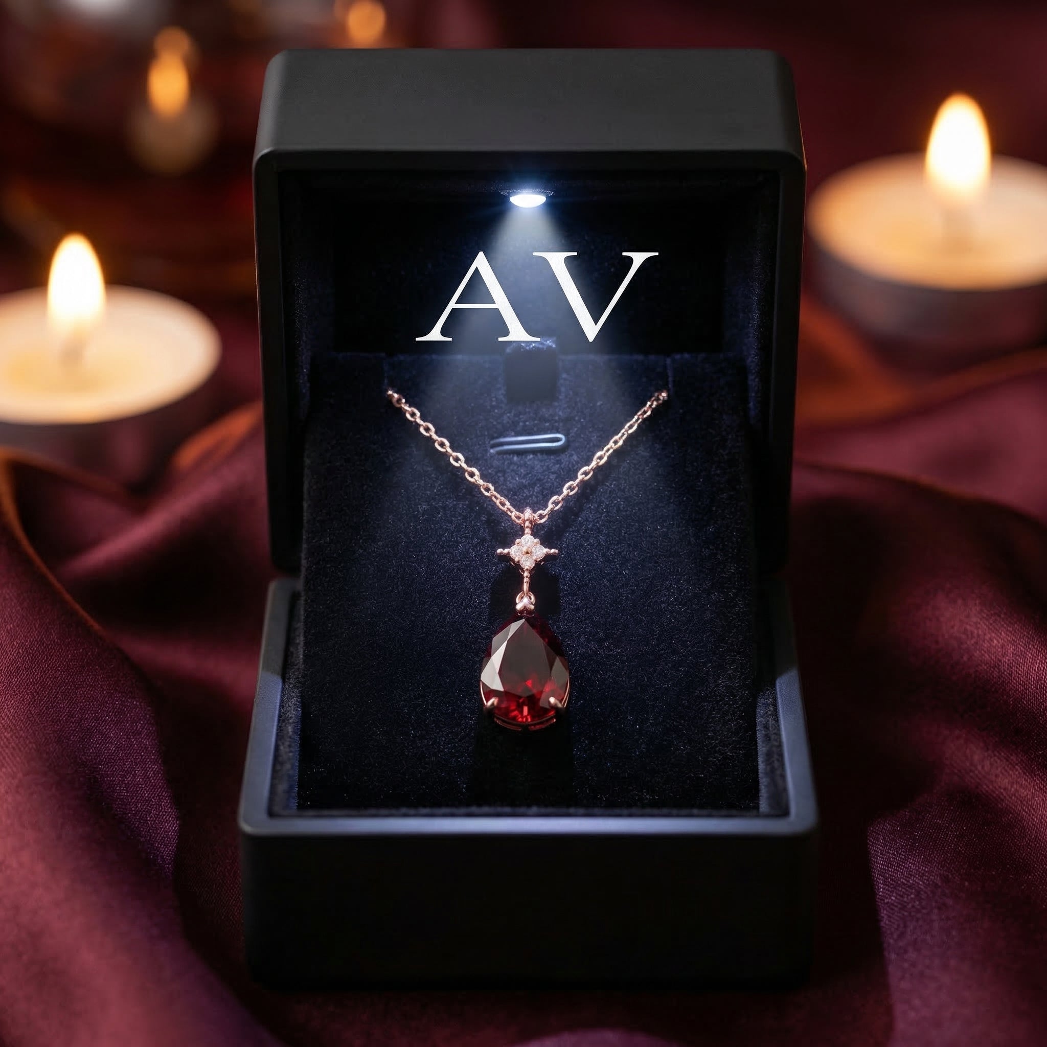 18K rose gold pear-cut garnet necklace presented in a black LED-lit jewelry box with the AV logo.