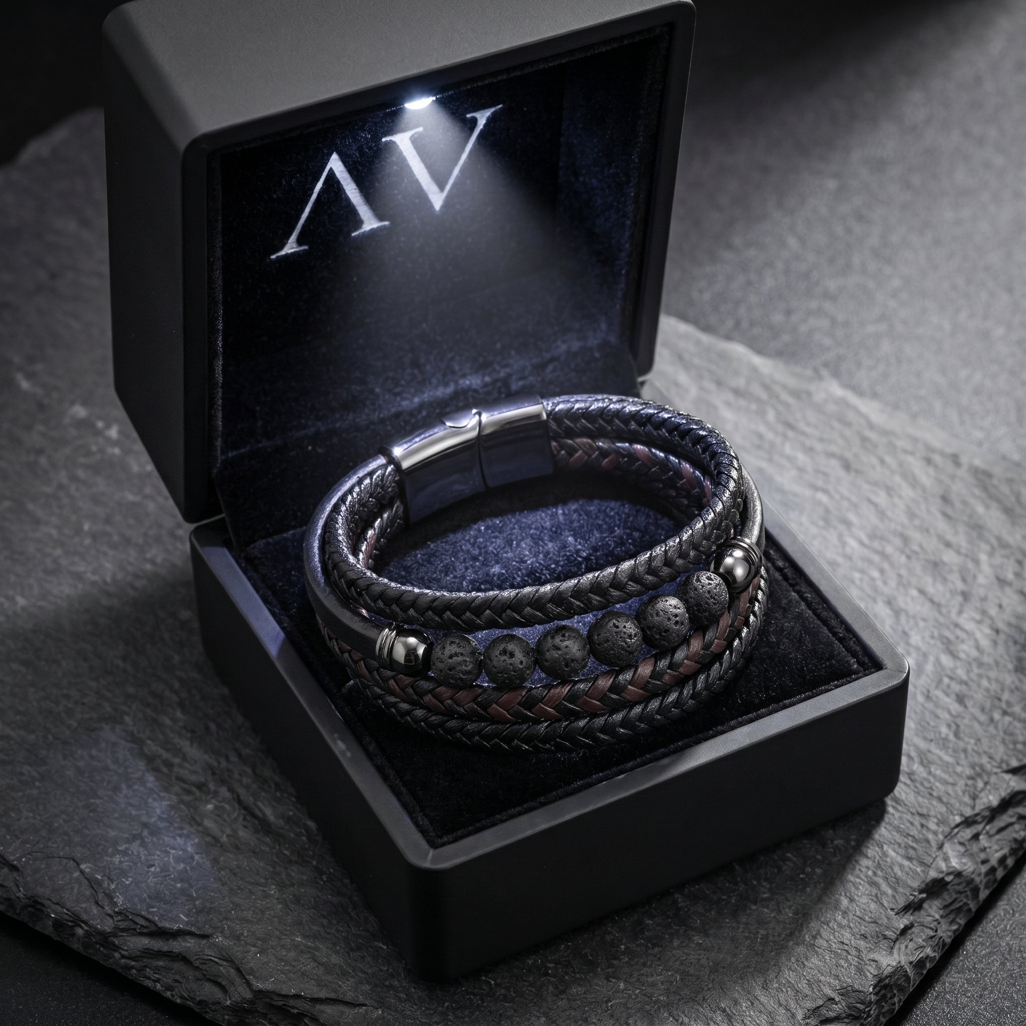 Black Outrider leather and lava stone bracelet presented in a premium LED-lit gift box with AV branding.