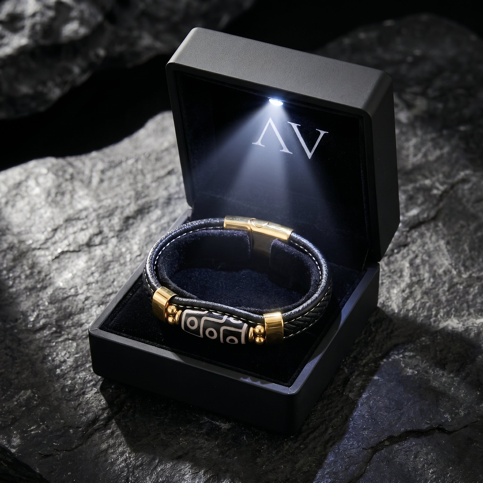 The Enigma gold and leather bracelet presented in a premium black LED-lit jewelry gift box.