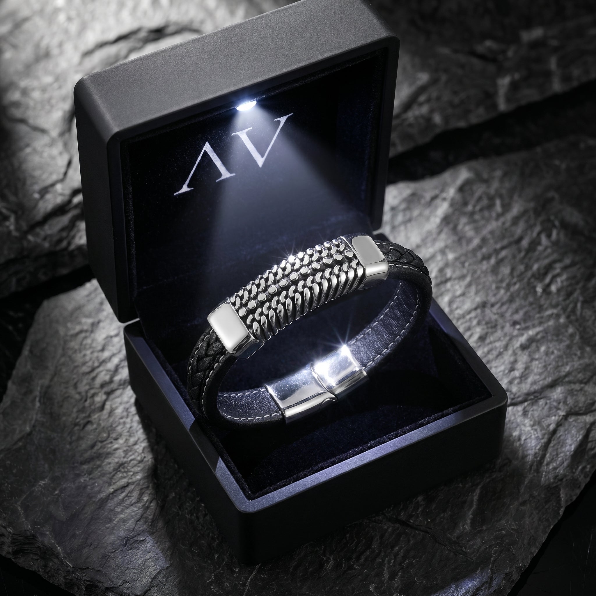 The Kinetic Bracelet displayed inside a premium black LED-lit gift box on a dark stone surface.