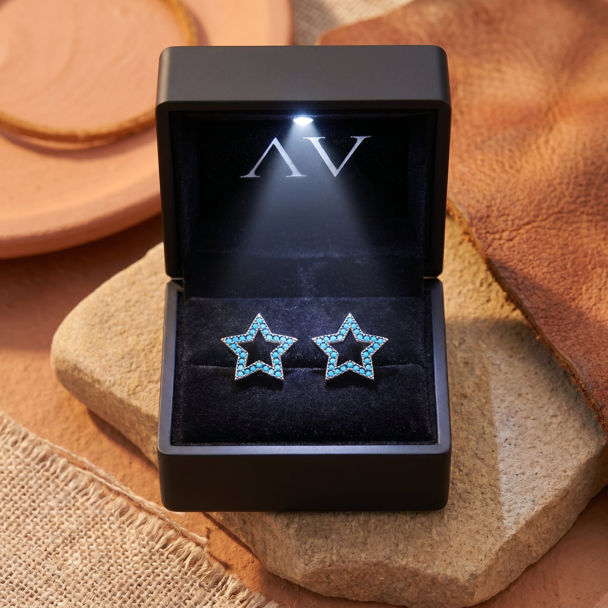 Turquoise star earrings in silver finish presented inside a premium black LED-lit jewelry gift box.