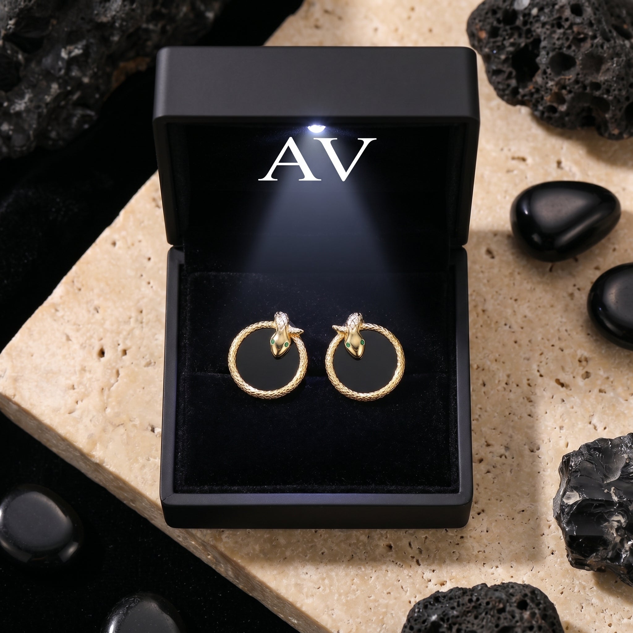 18K gold plated Serpens onyx earrings presented in a black illuminated jewelry gift box with AV branding.