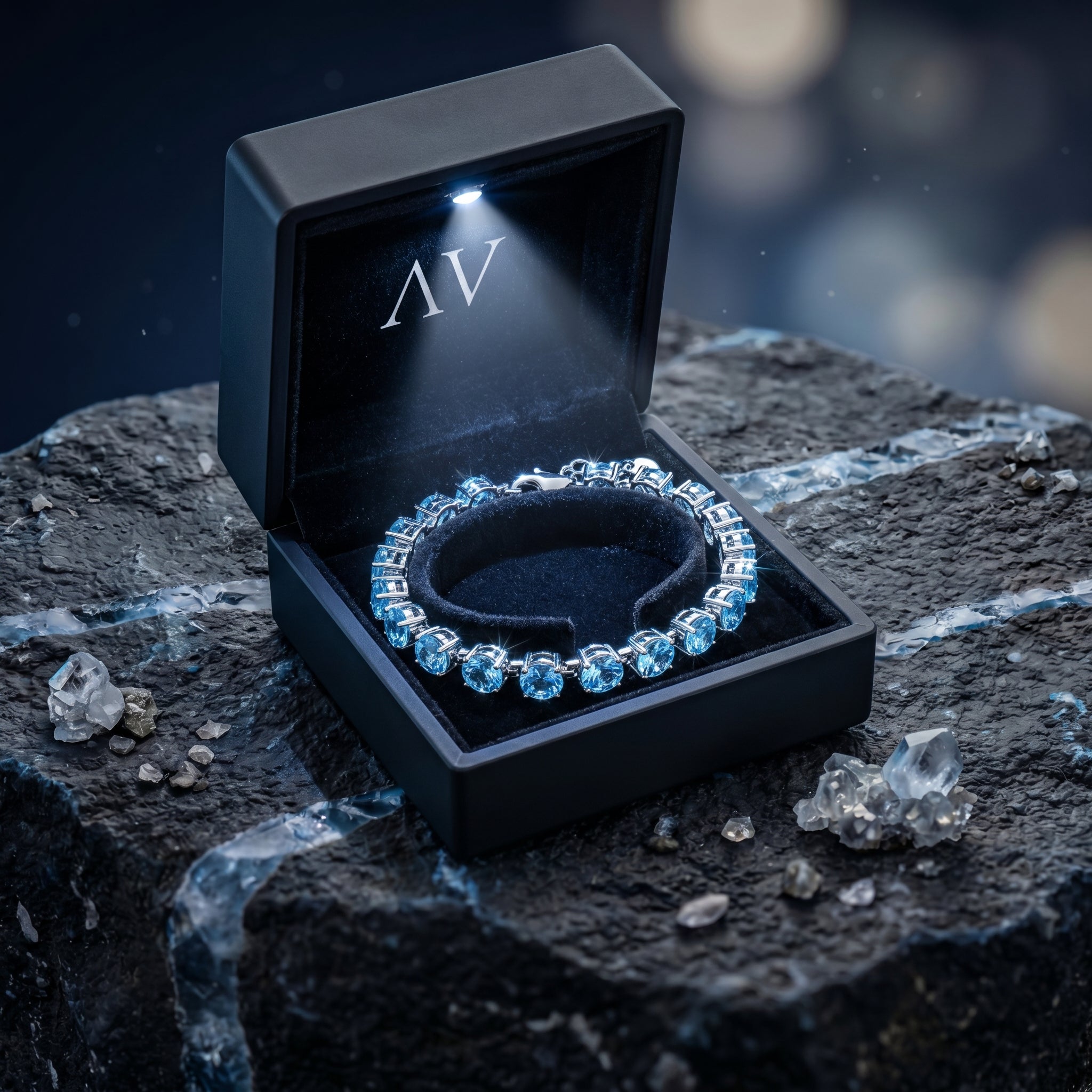 Swiss blue topaz tennis bracelet inside a lighted black gift box on a dark stone surface.