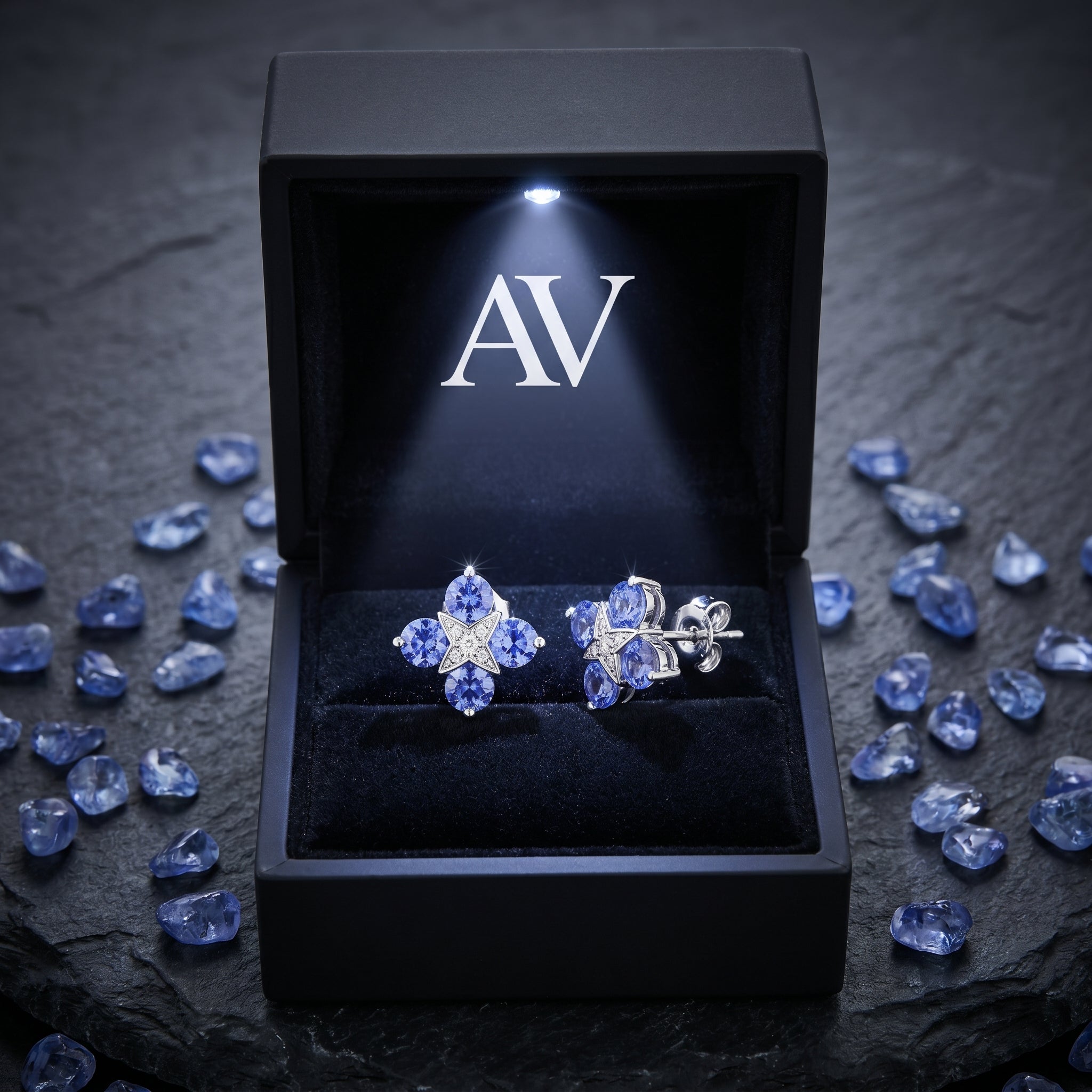 Tanzanite cluster earrings inside a black LED-lighted gift box with raw gemstone accents.
