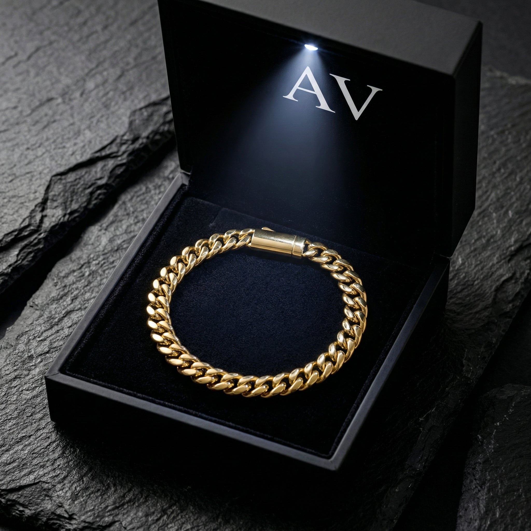 Gold stainless steel 5mm Cuban link bracelet inside a black AV branded gift box with an LED light.