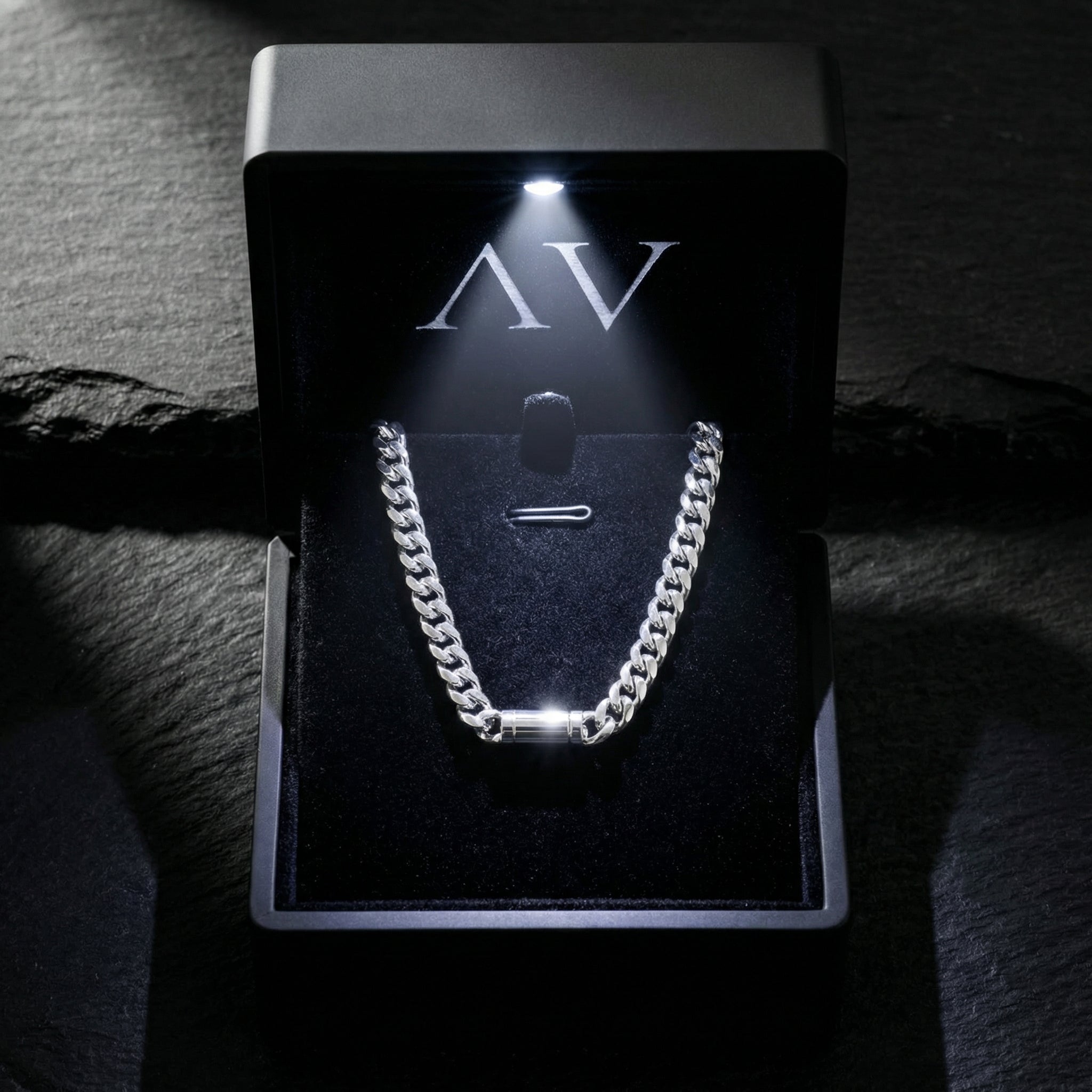 Silver Cuban link chain presented in a black branded jewelry box with an LED light.