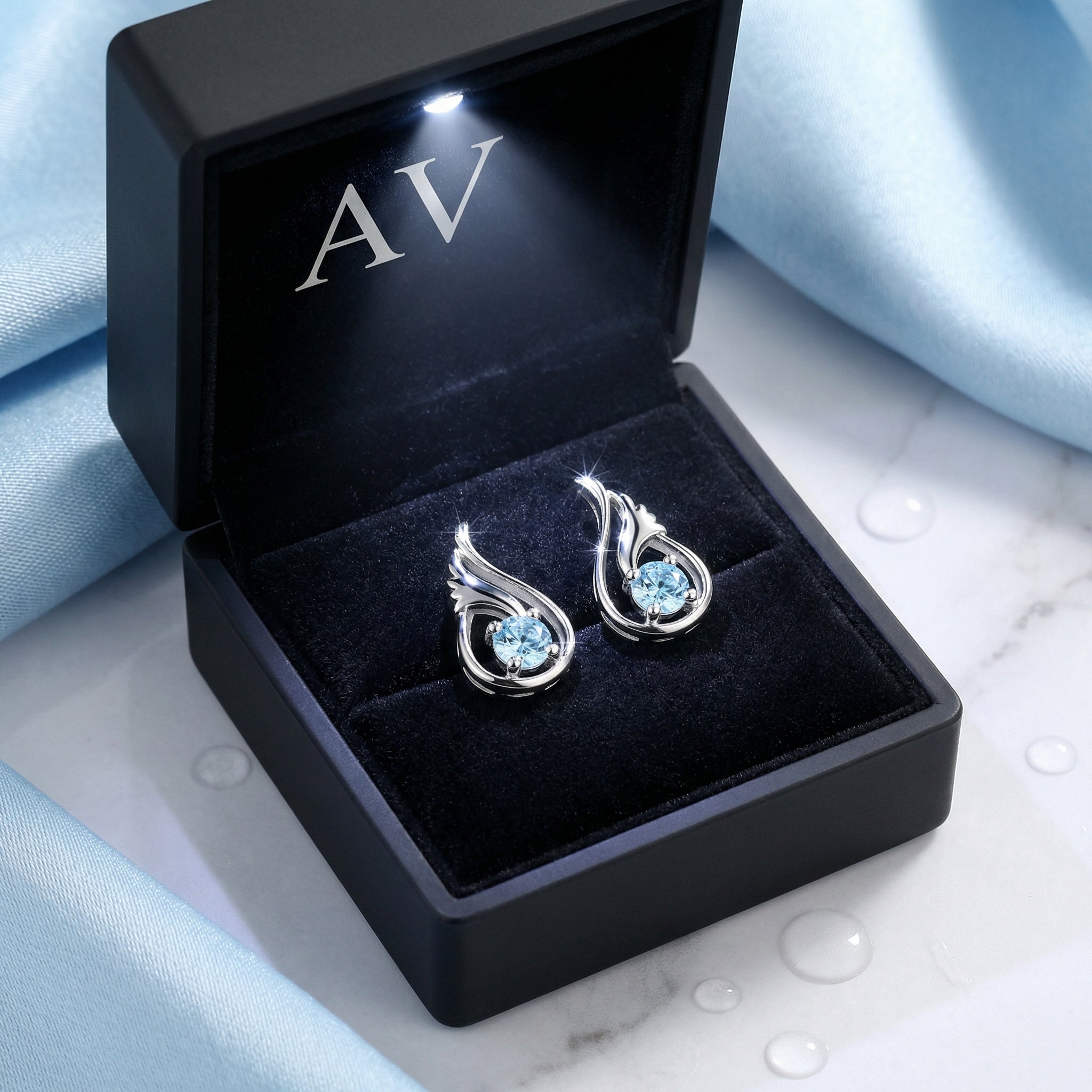 Sterling silver simulated aquamarine drop earrings inside a black LED-lit presentation jewelry box.