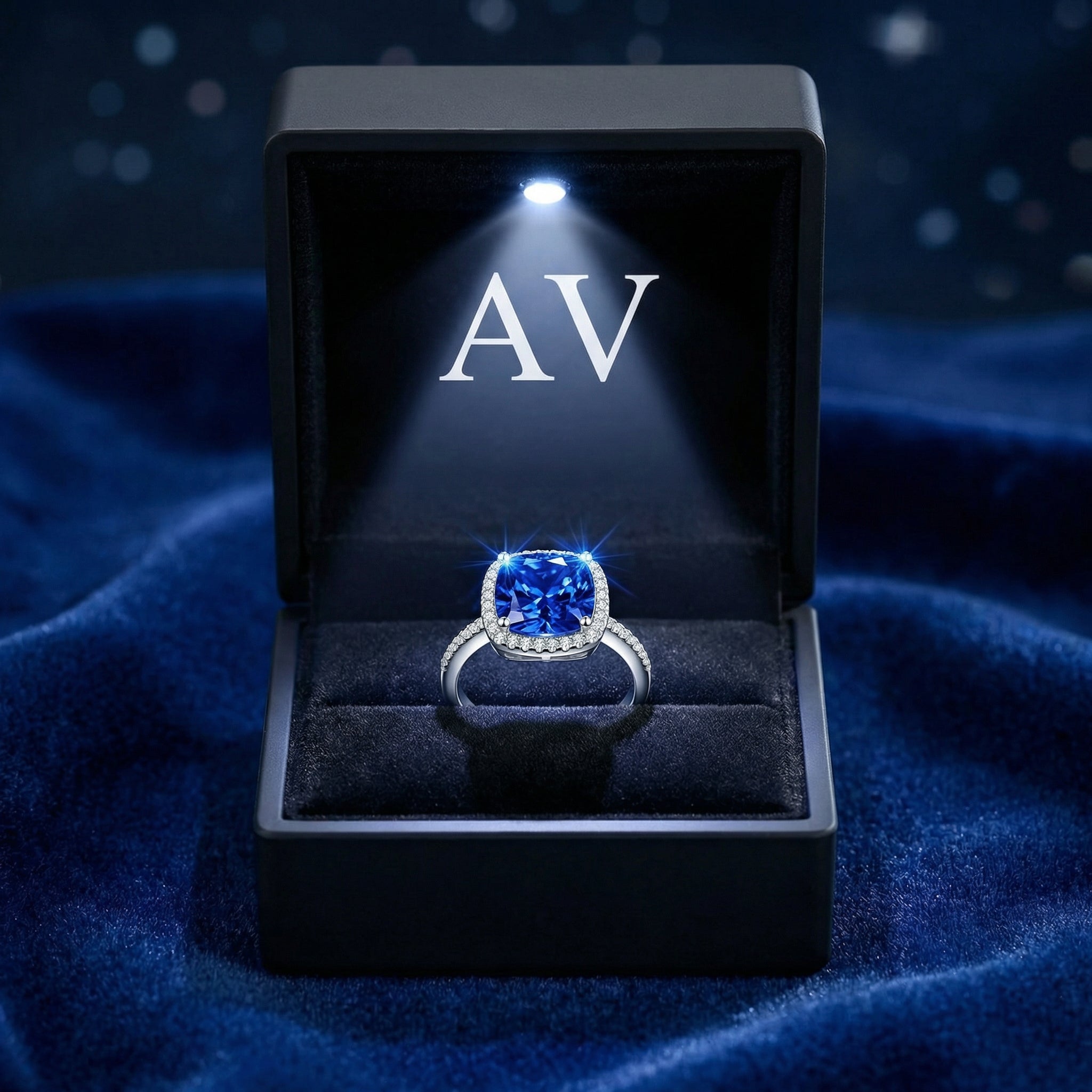 Cushion-cut simulated sapphire ring in S925 sterling silver inside a black LED-lighted jewelry box.