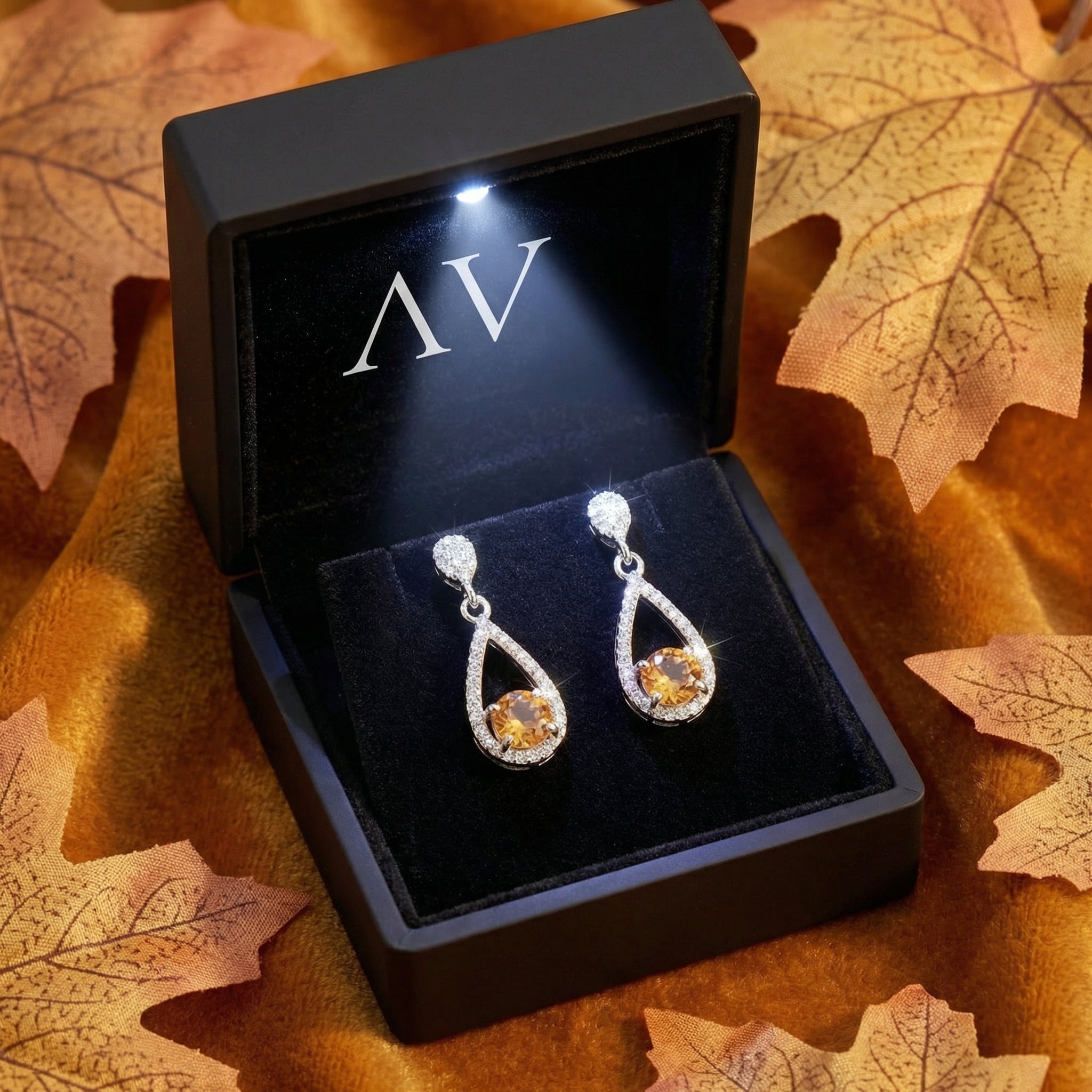 S925 sterling silver simulated topaz drop earrings in a black LED-lit jewelry presentation box.