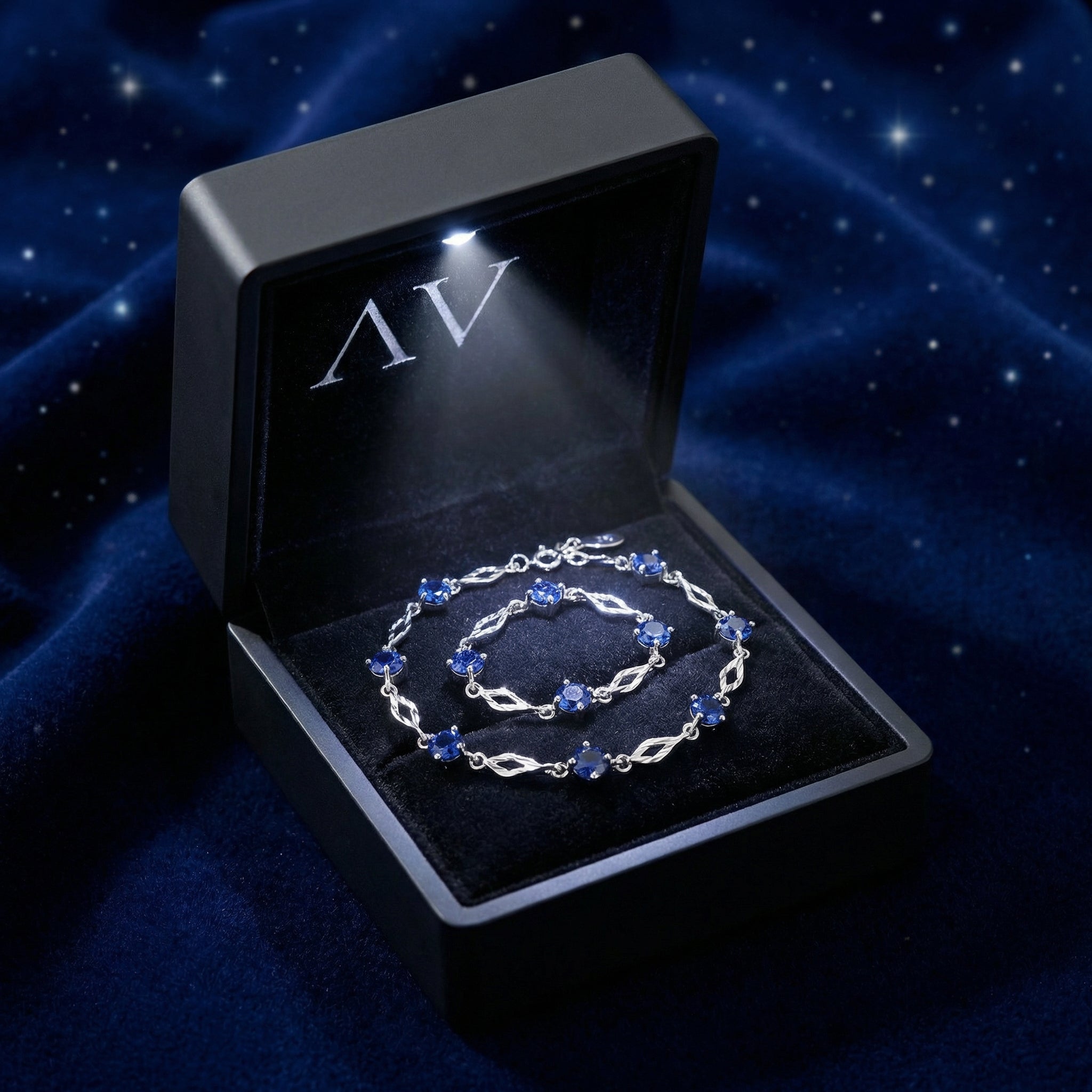 Nerienne blue sapphire station bracelet in S925 sterling silver inside a black lighted presentation box.