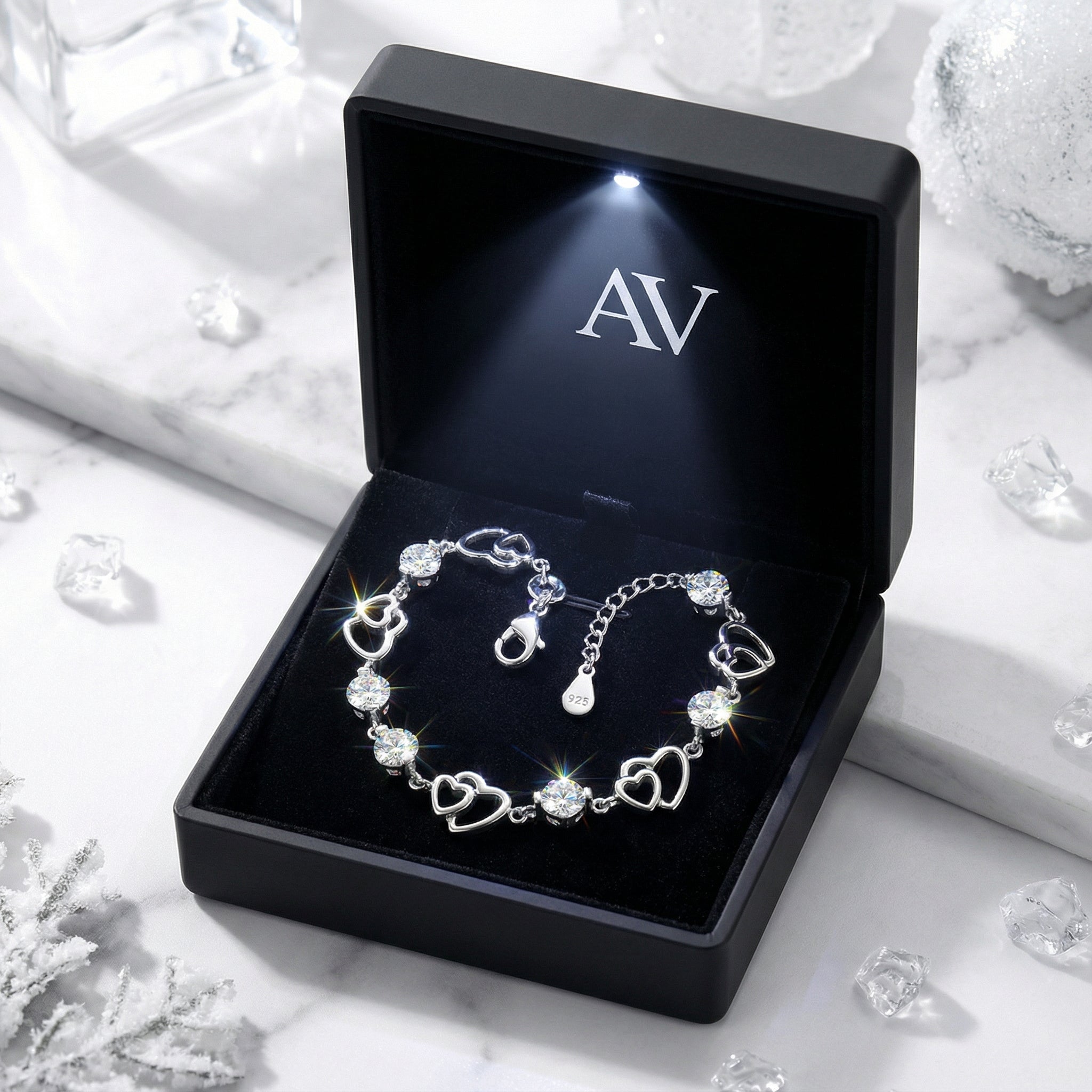 S925 sterling silver heart bracelet with simulated diamonds inside a black LED-lit AV branded jewelry gift box.