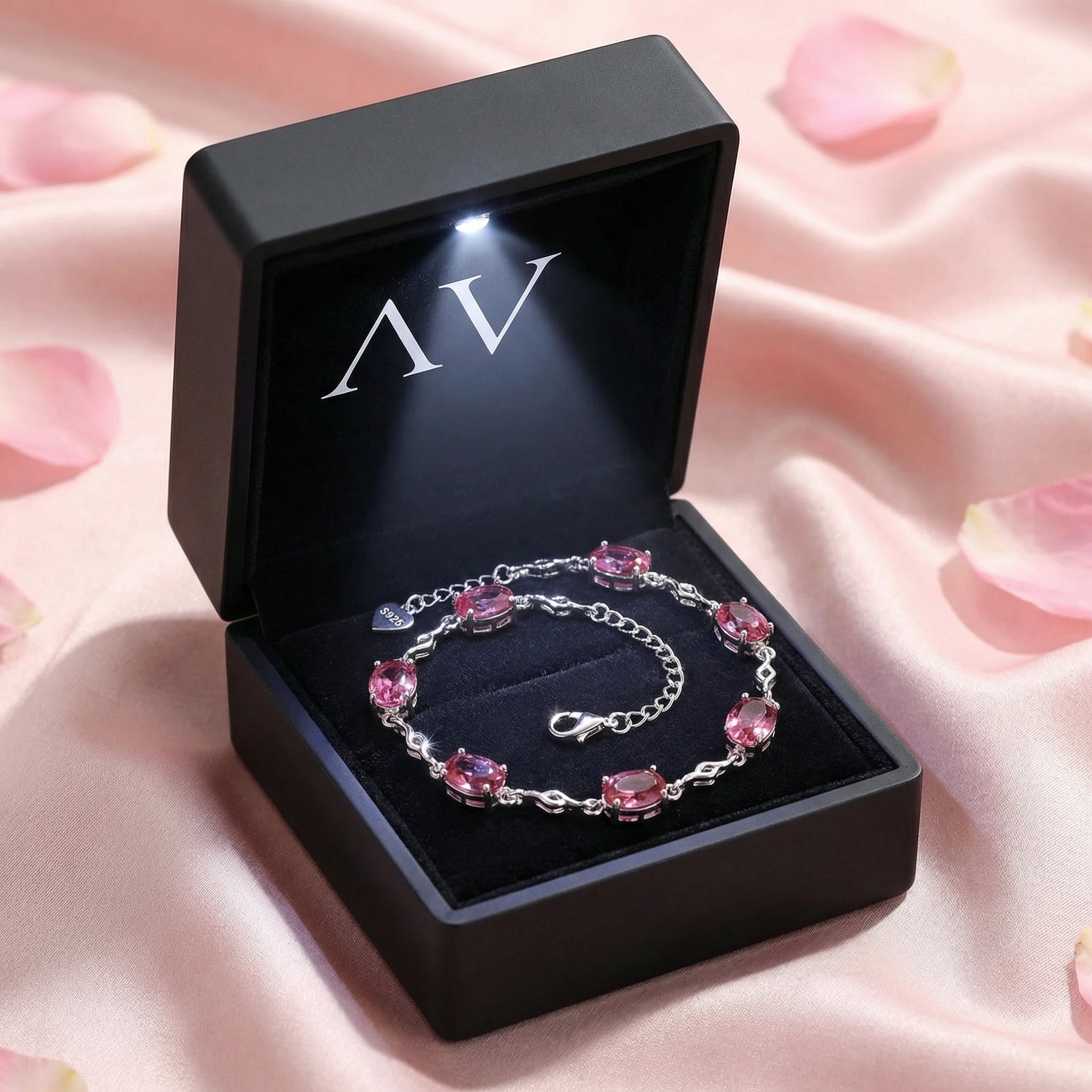 Oval pink tourmaline silver bracelet inside a black LED-lighted jewelry presentation box.