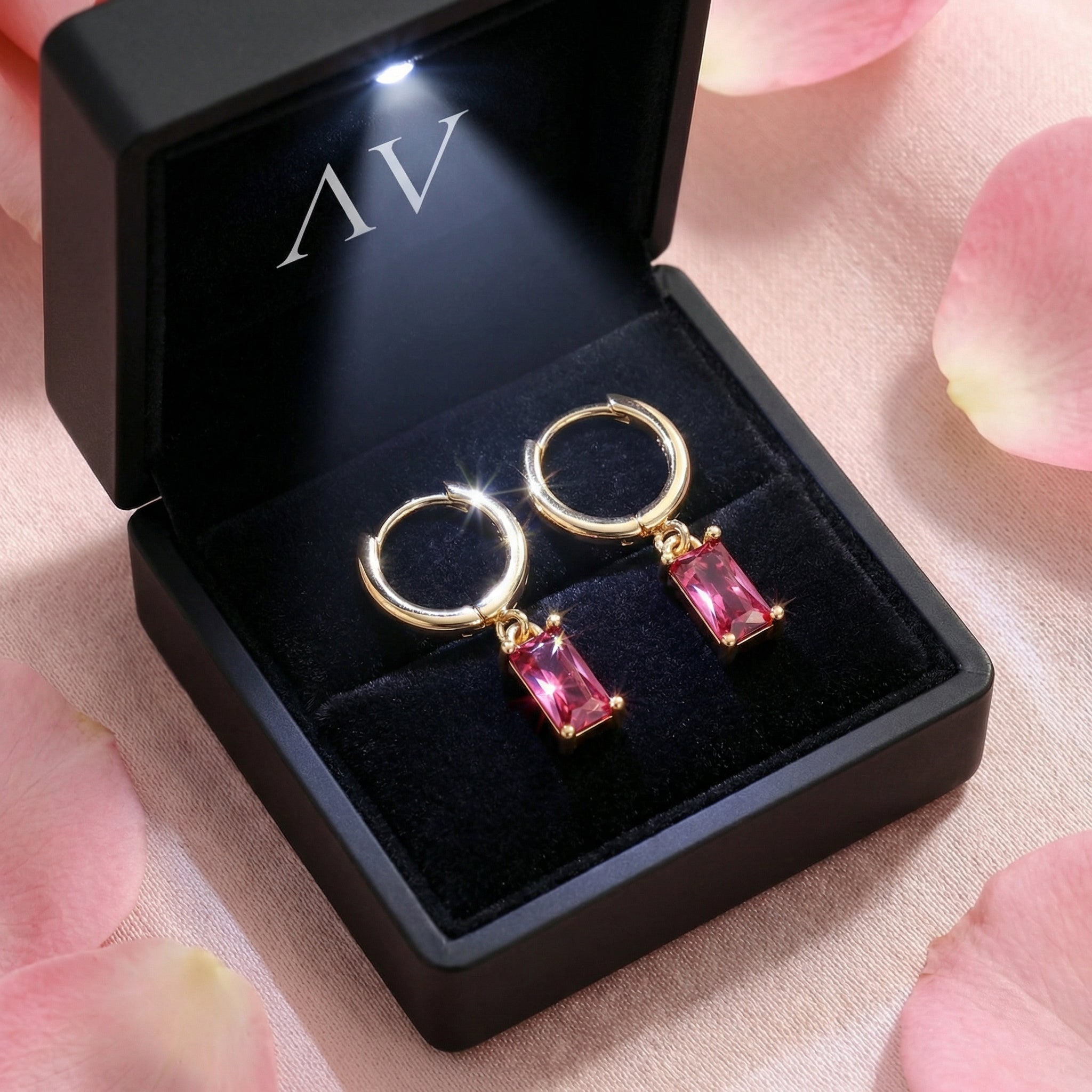 Gold vermeil pink tourmaline drop earrings inside a black LED-lighted jewelry box on pink fabric.