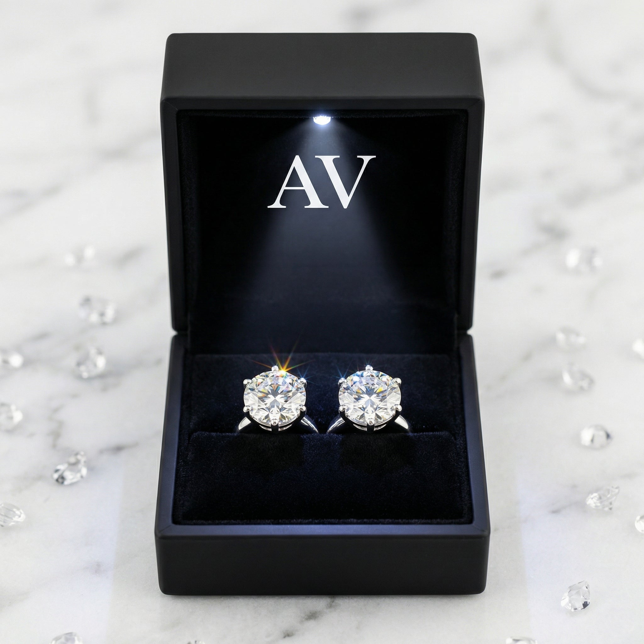 Pair of round cut simulated diamond stud earrings in a black LED-lit jewelry gift box.
