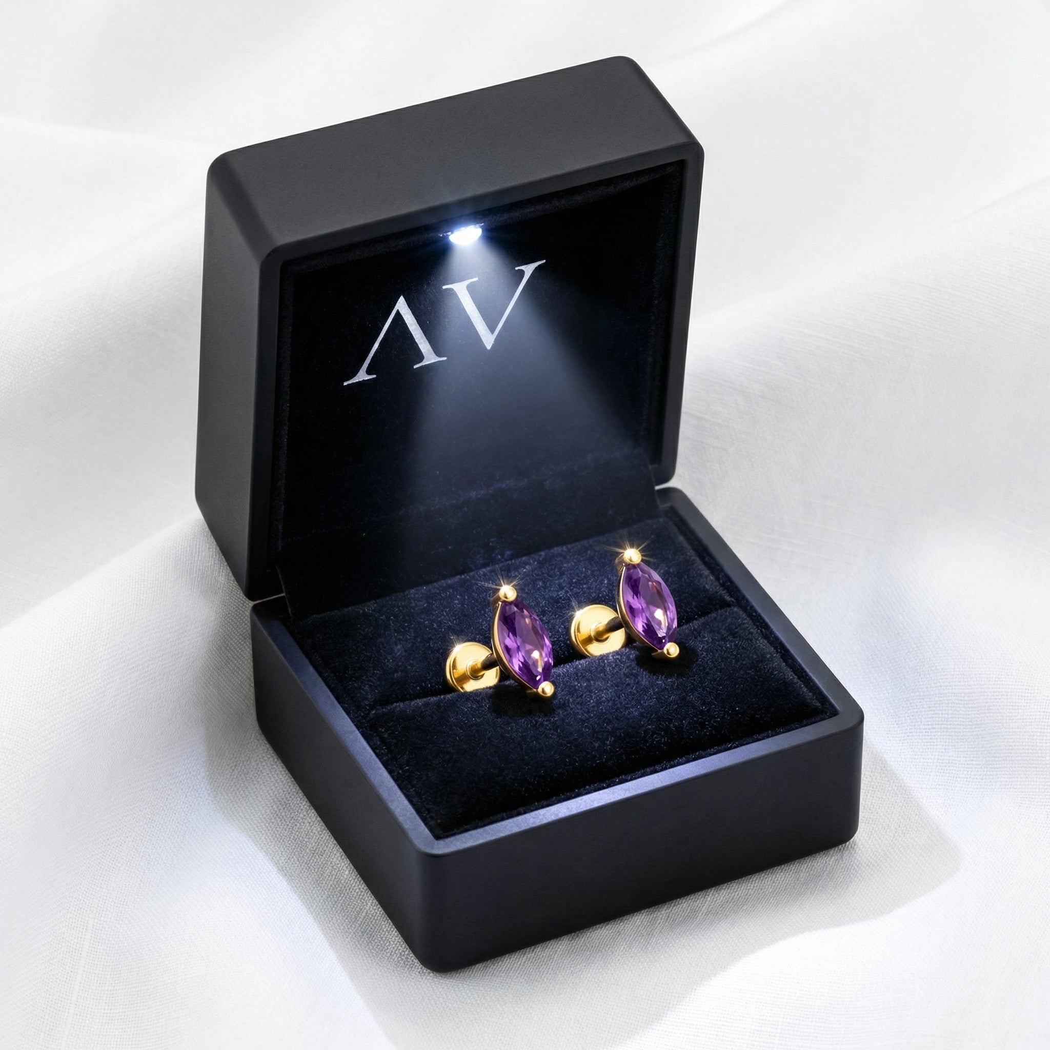The Marcella Studs marquise-cut purple simulated amethyst earrings in 18K gold vermeil in a lighted black gift box.