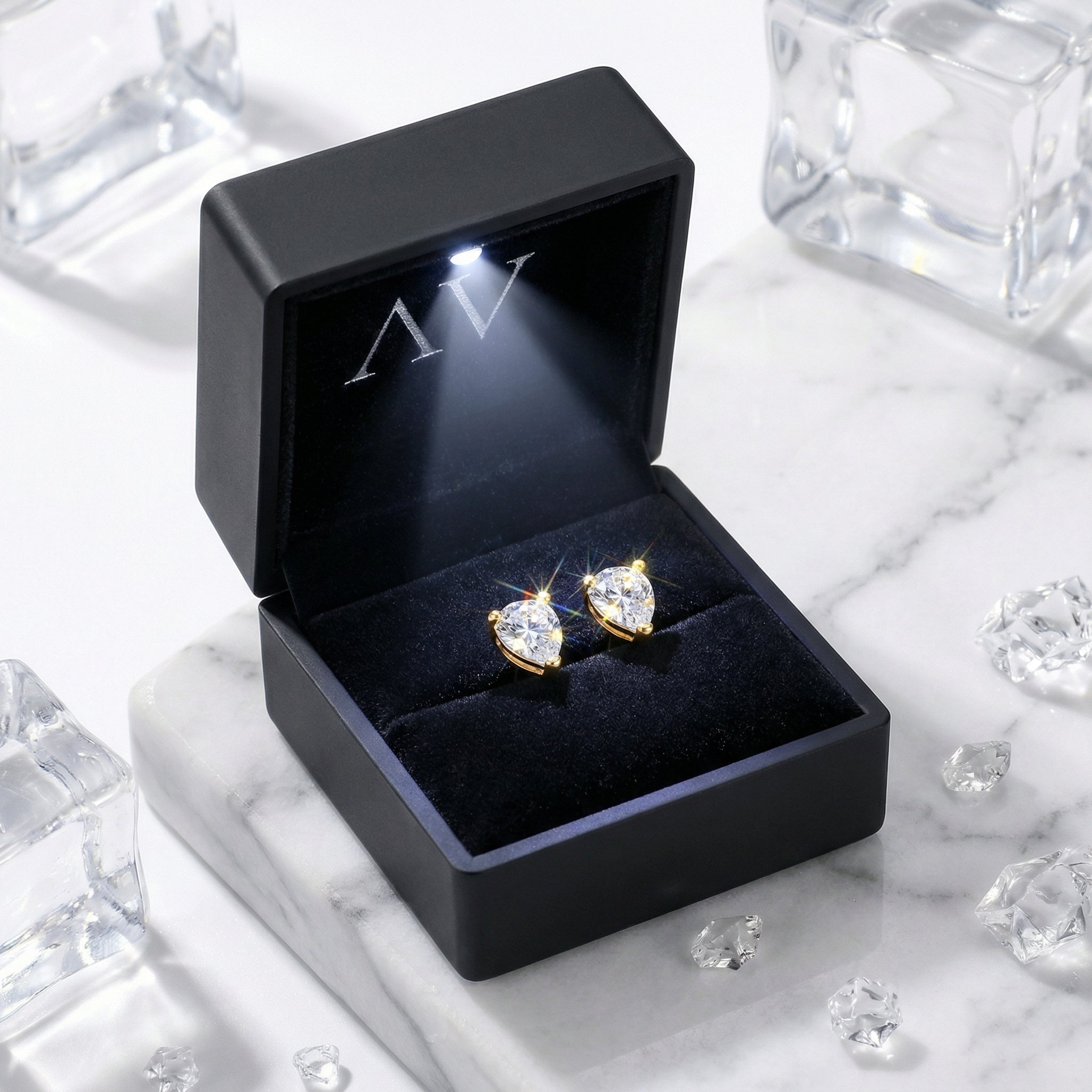Pear-cut simulated diamond stud earrings in 18K gold vermeil presented in a lighted black jewelry gift box.