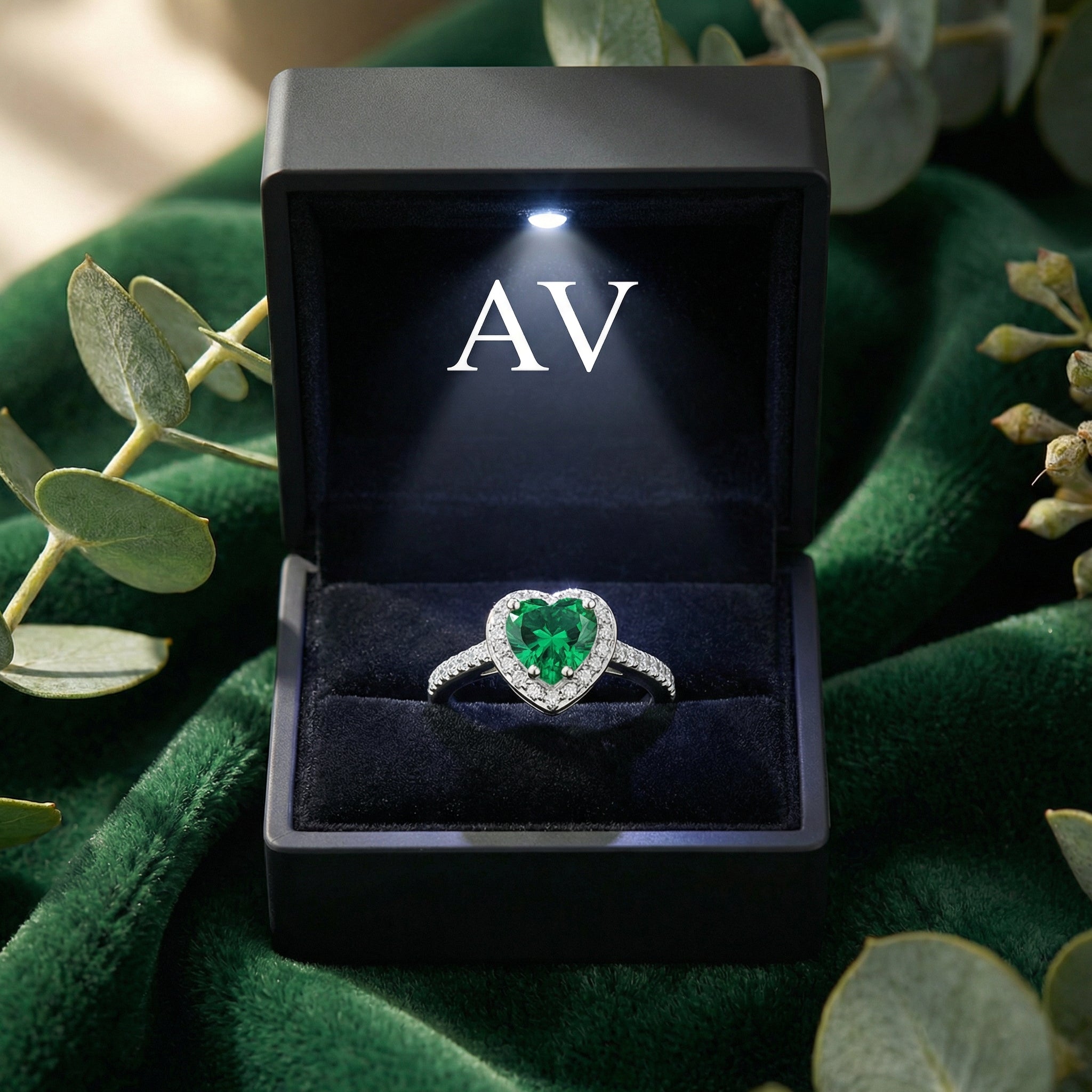 Heart-cut simulated emerald sterling silver ring inside a lighted black AV jewelry presentation box.