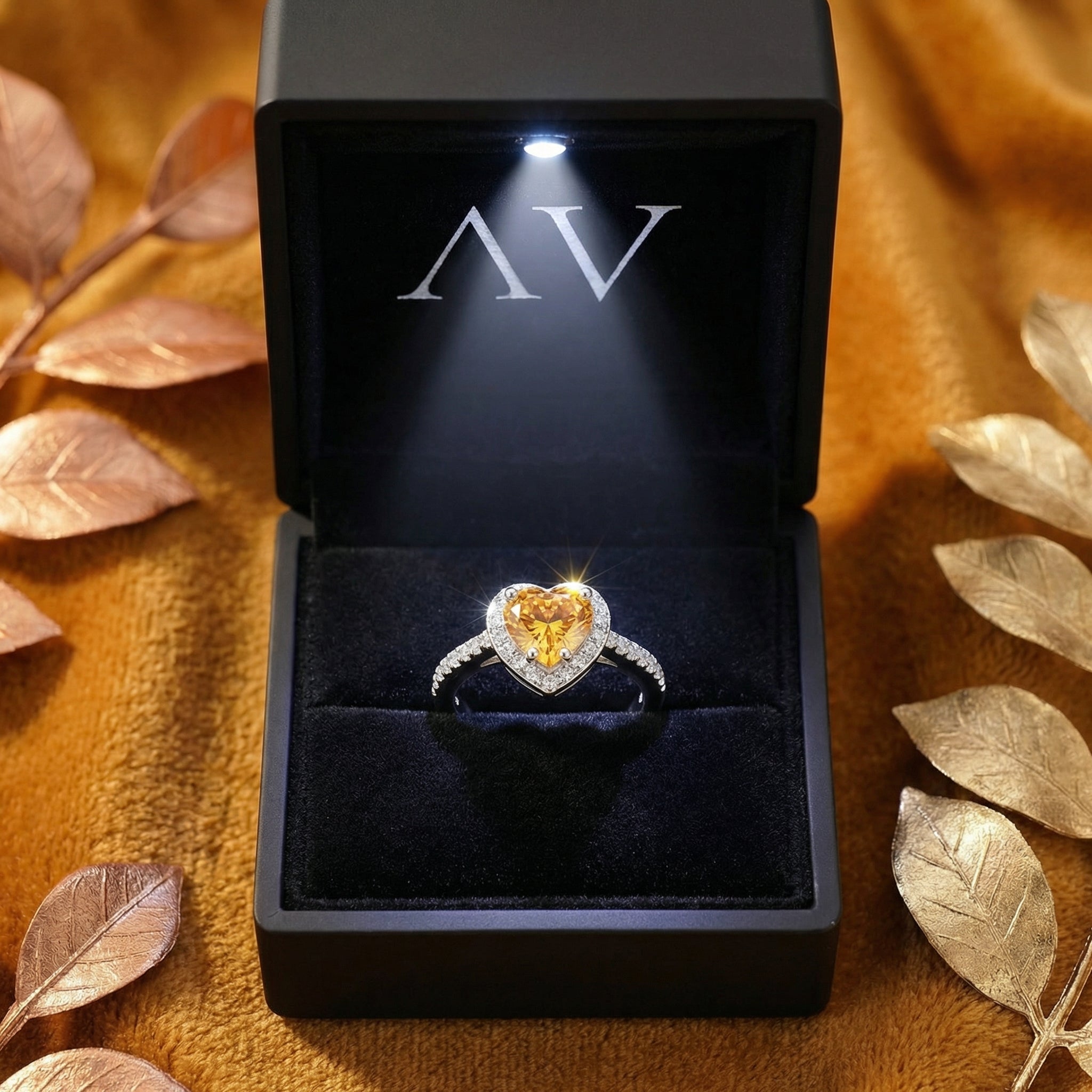 Heart-cut simulated topaz sterling silver halo ring inside a black LED-lit presentation box.