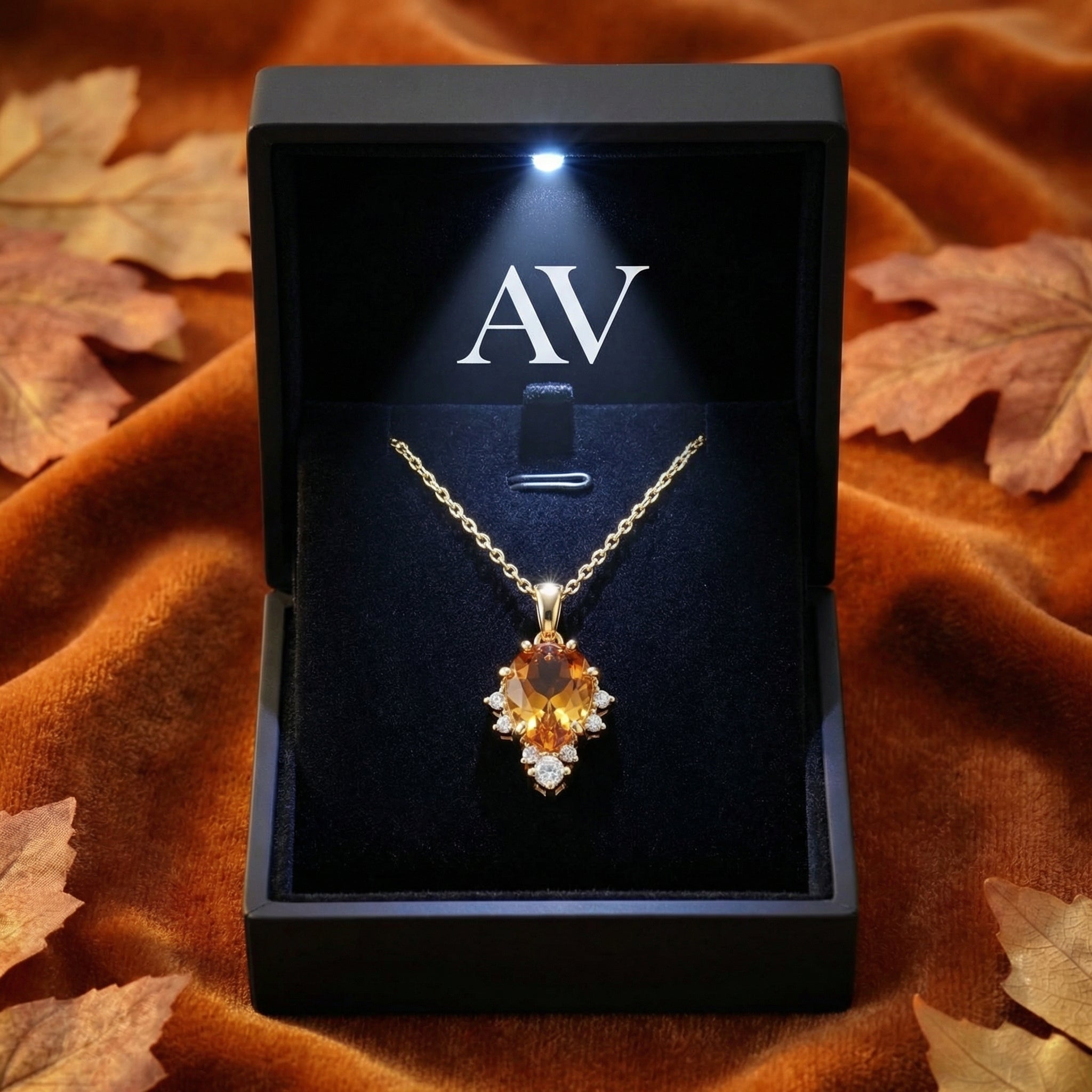 Pear-cut simulated topaz necklace in 18K gold vermeil inside a black LED-lit jewelry presentation box.