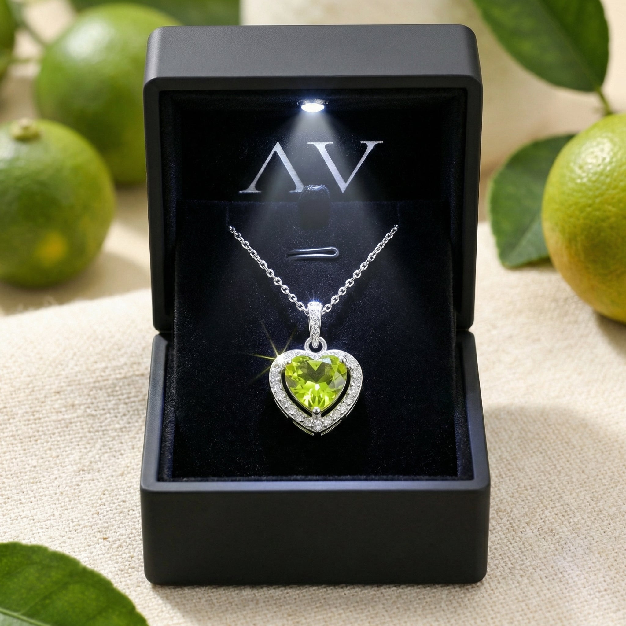 Heart-cut simulated peridot necklace displayed in a black LED-lit jewelry box, highlighting the silver halo design.