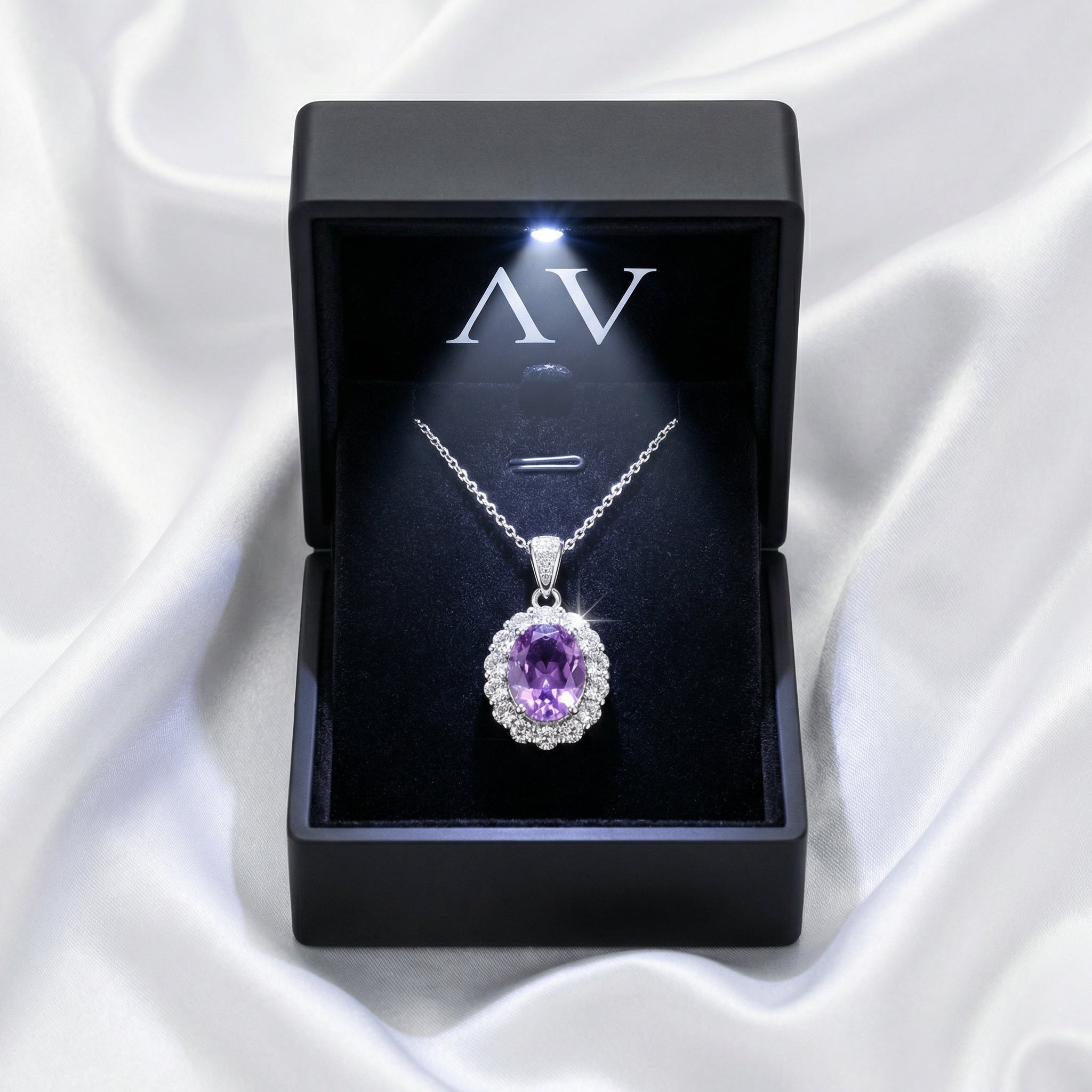 Oval simulated amethyst halo necklace in sterling silver inside a lighted black jewelry box.
