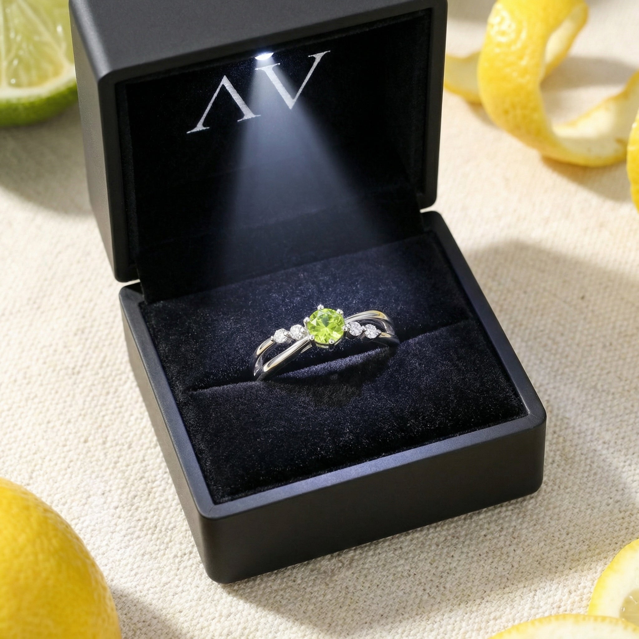 Zelinda sterling silver bypass ring with a green peridot displayed in a black LED-lit jewelry box.