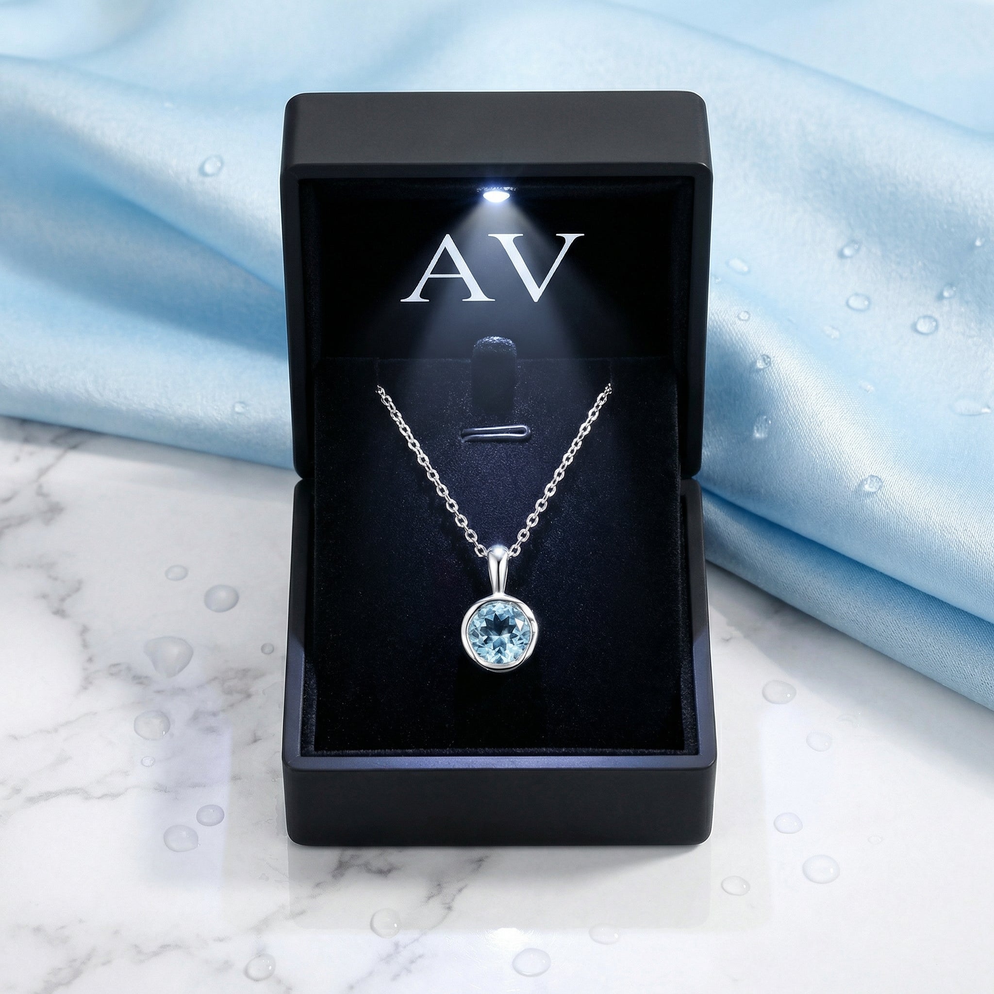 Marella sterling silver and simulated aquamarine necklace presented in a black lighted jewelry gift box.