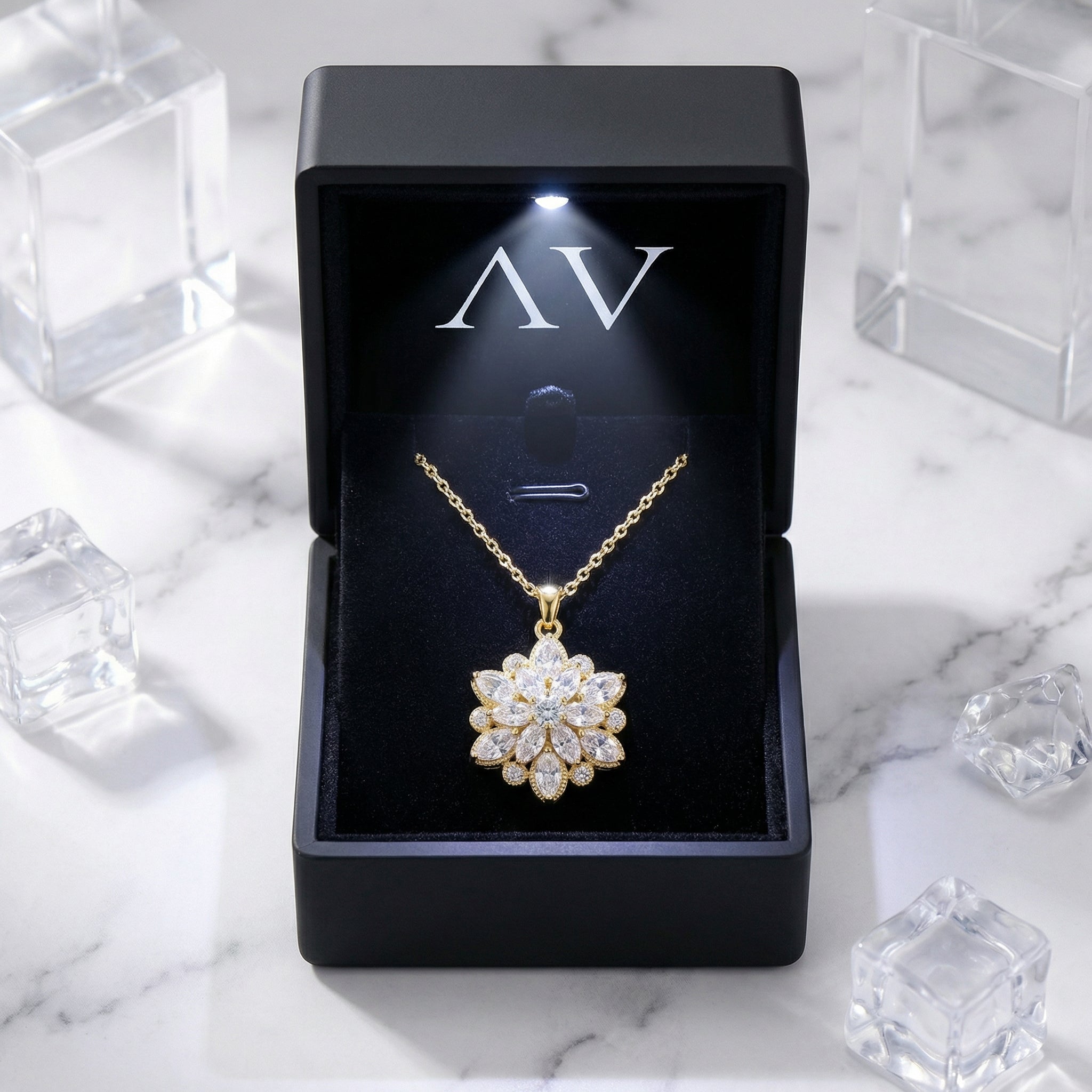 Gold stainless steel floral necklace with simulated diamonds in a lighted black jewelry gift box.