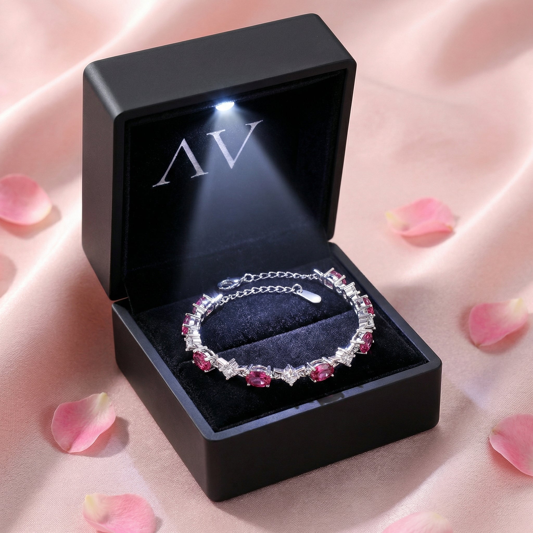 Sterling silver pink tourmaline bracelet displayed in a black LED-lighted jewelry gift box on pink silk.
