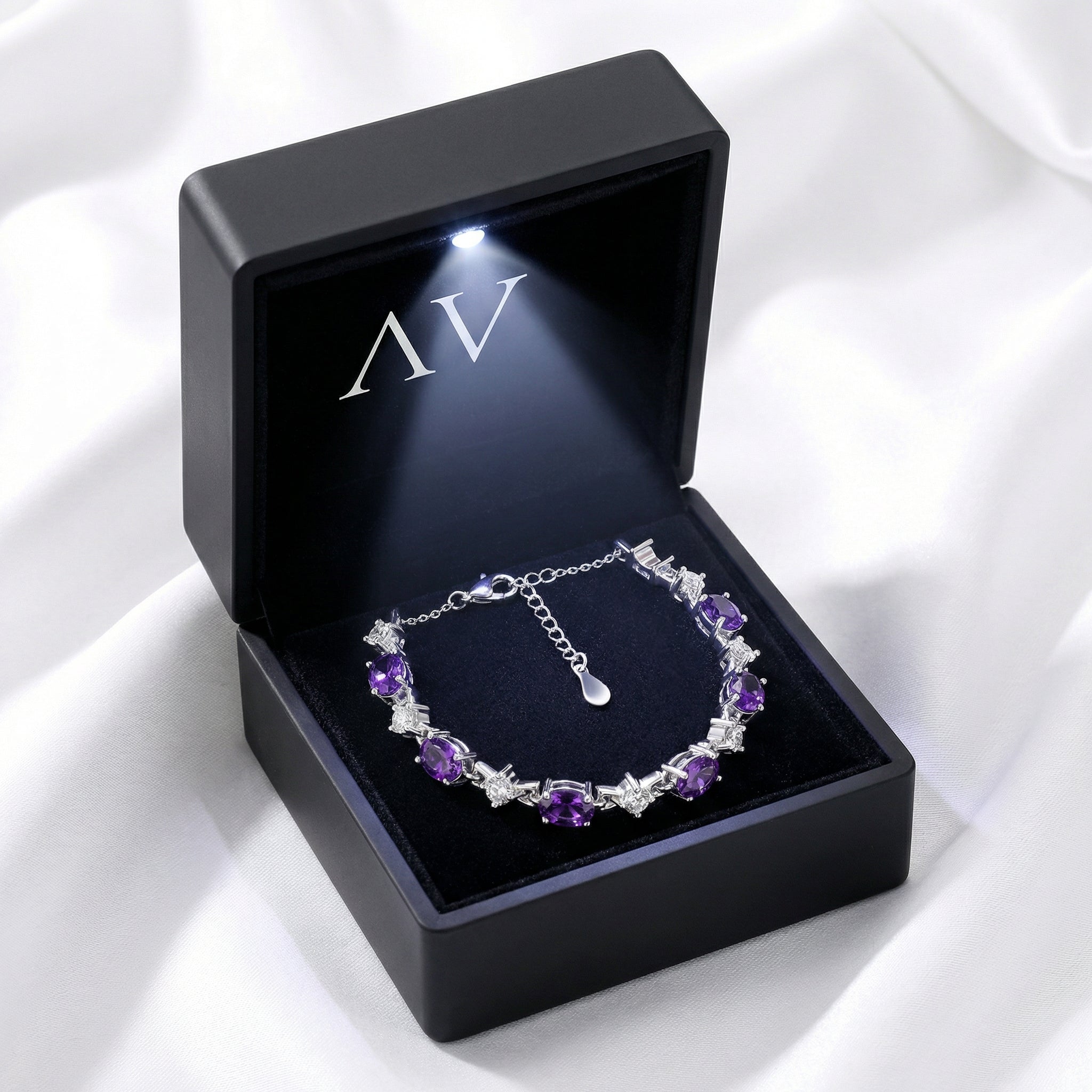 Lucina sterling silver amethyst tennis bracelet in a black lighted gift box with silver AV logo.