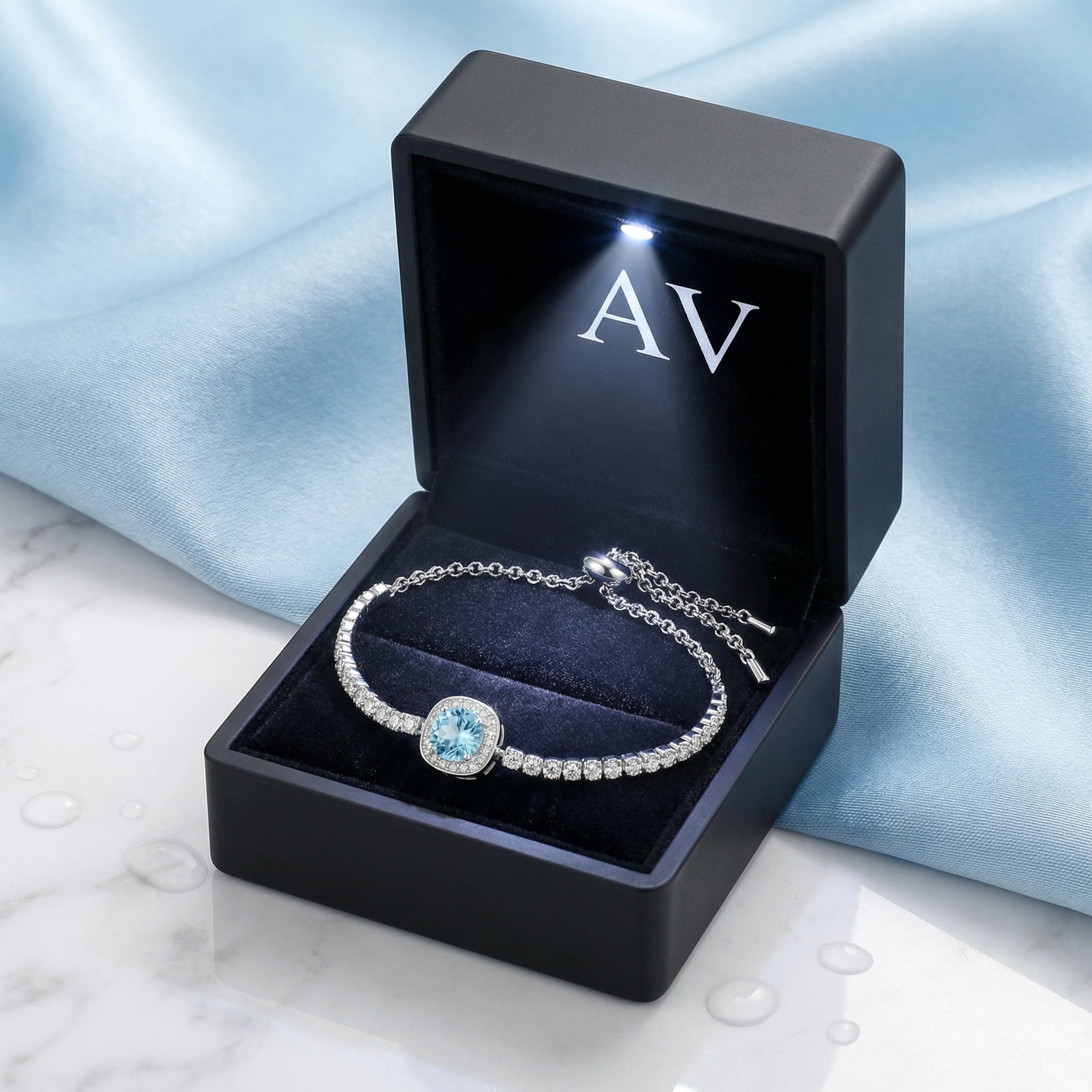 Sterling silver simulated aquamarine halo bracelet presented in a black LED-lit jewelry gift box.