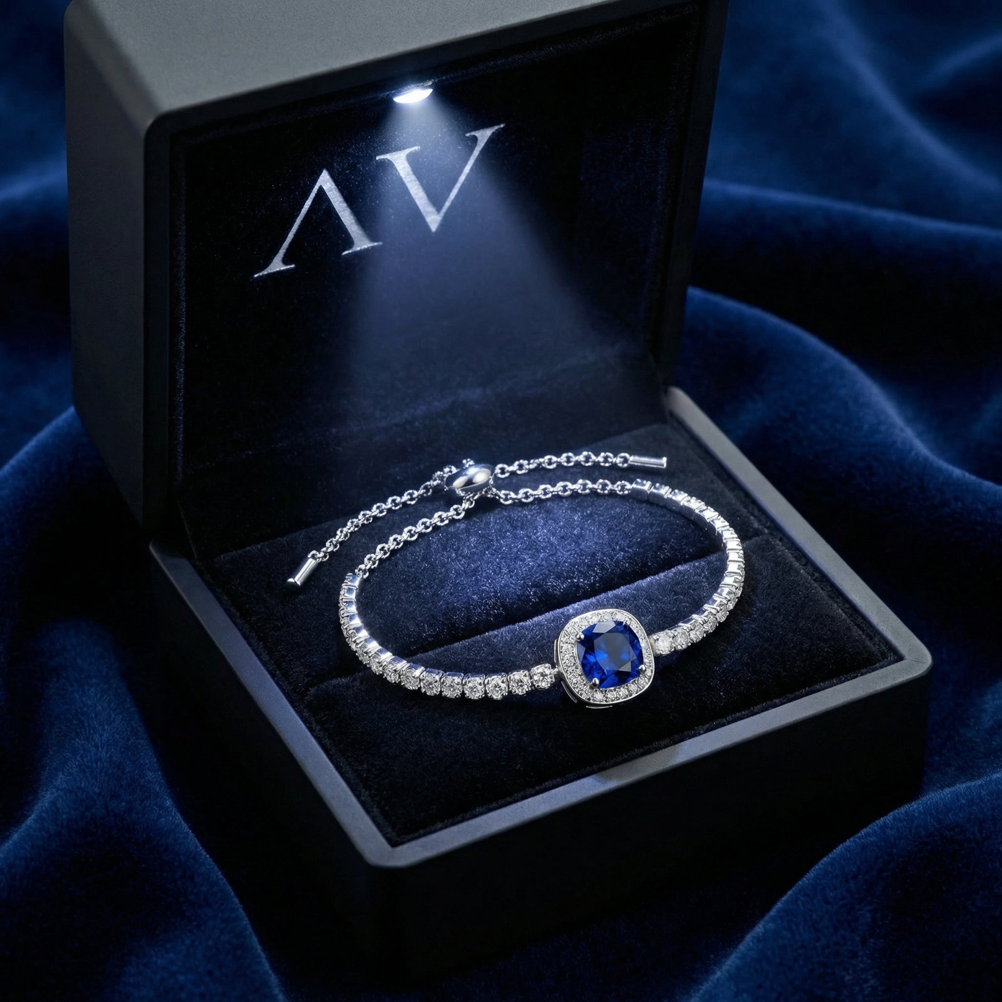 Sterling silver simulated sapphire bolo bracelet inside a black LED-lighted jewelry gift box.