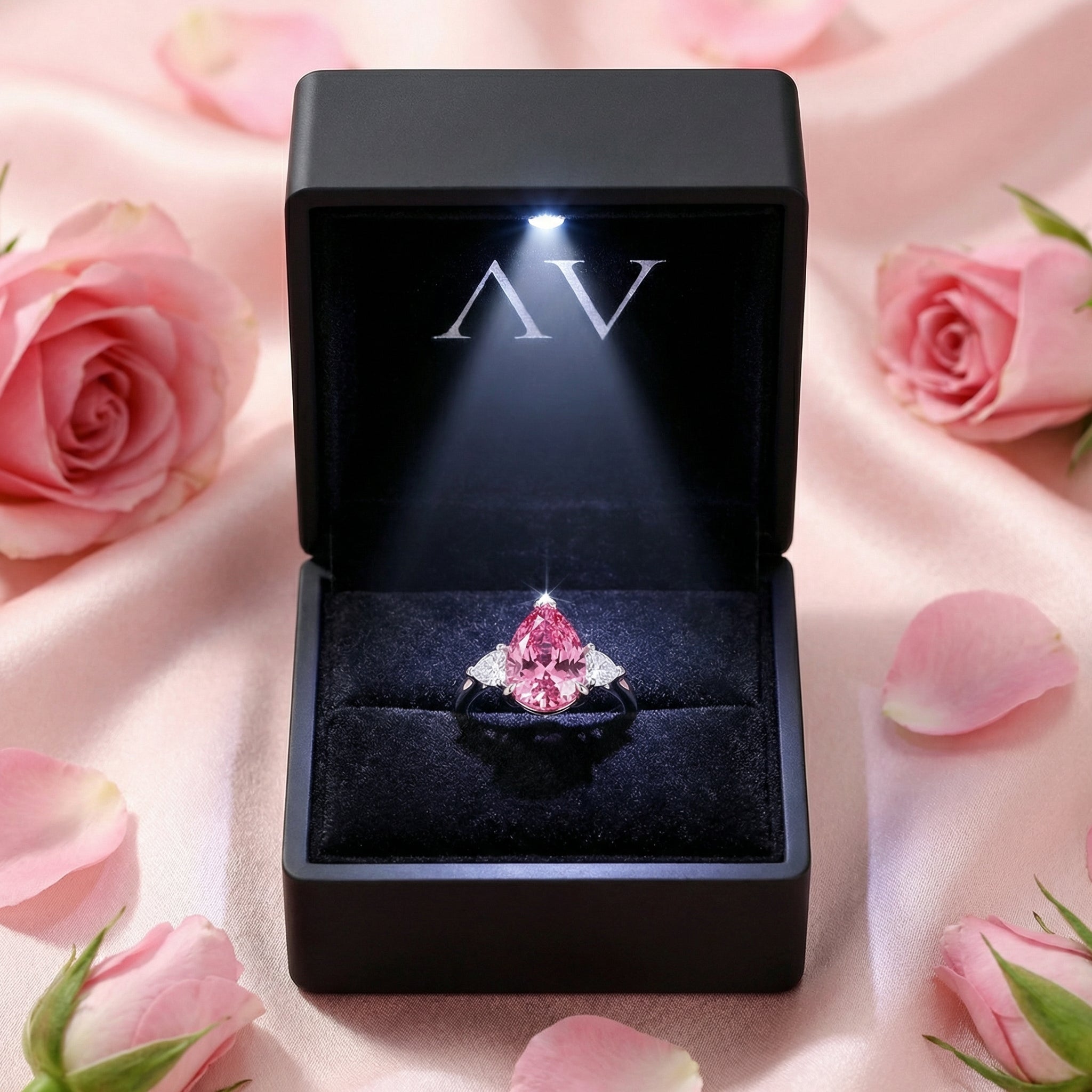 Pear-cut simulated pink tourmaline S925 sterling silver ring inside a black LED-lit gift box with pink roses.