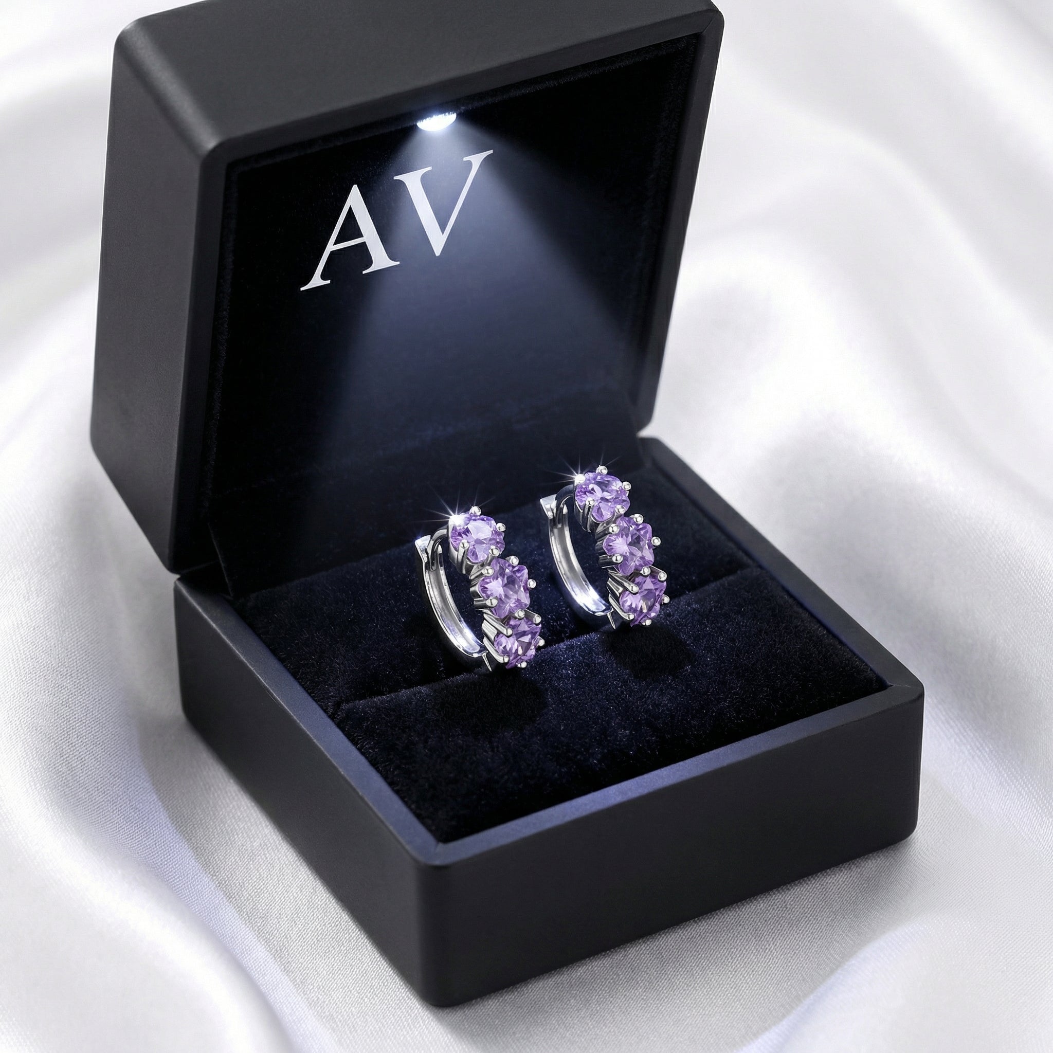 S925 sterling silver star-cut amethyst huggie earrings inside a premium black LED-lit jewelry gift box.