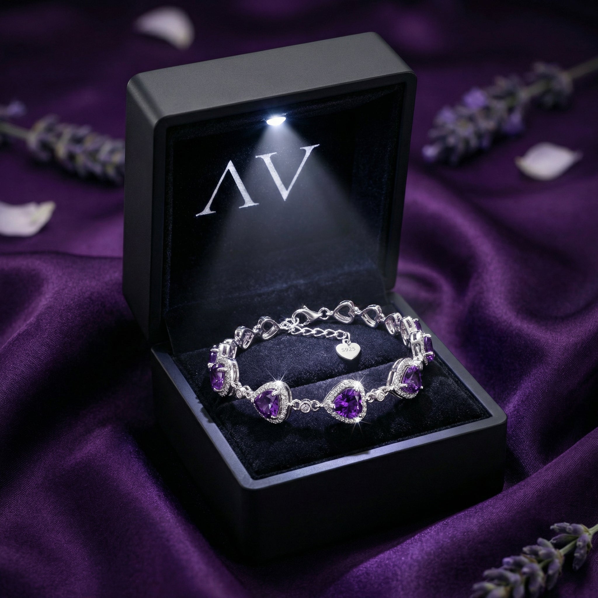 Sterling silver heart amethyst bracelet in a black lighted jewelry gift box on purple silk.