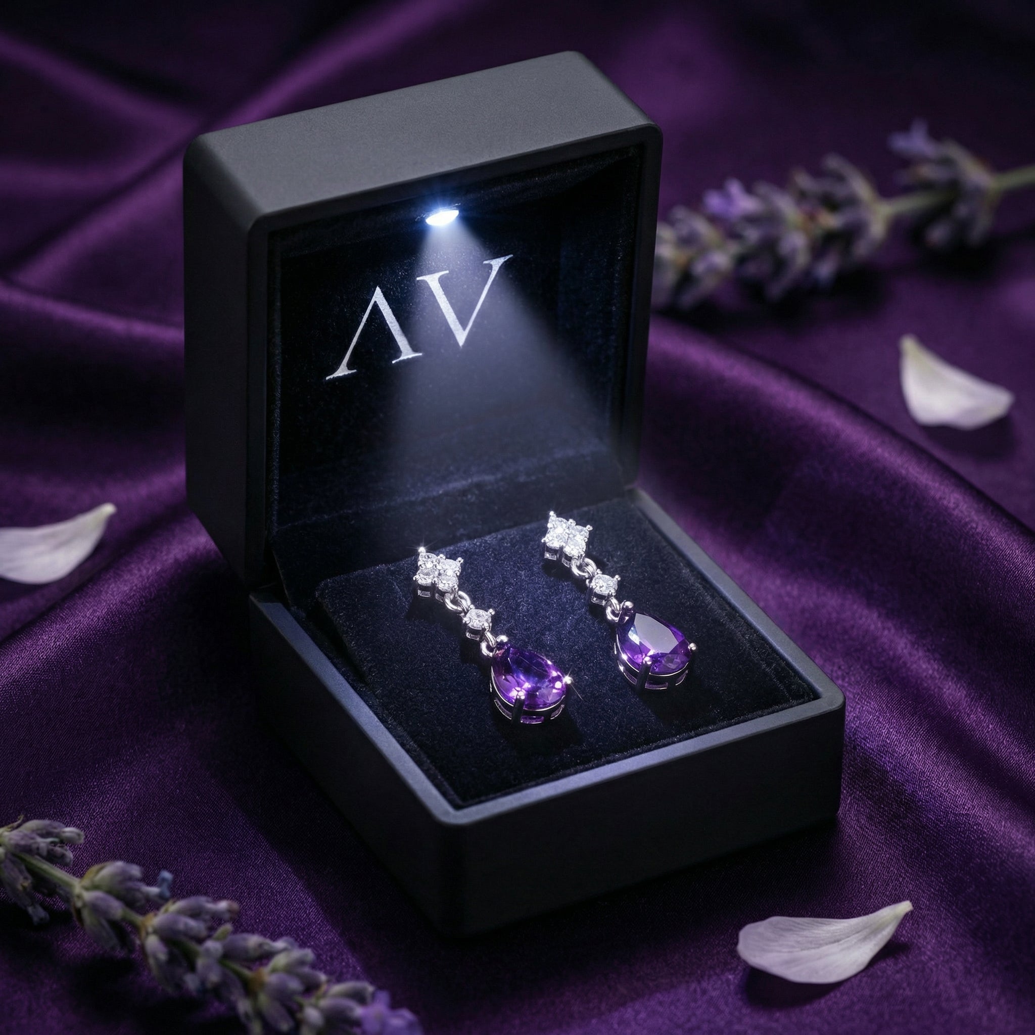 Sterling silver pear cut amethyst drop earrings inside a black LED-lighted jewelry presentation box.