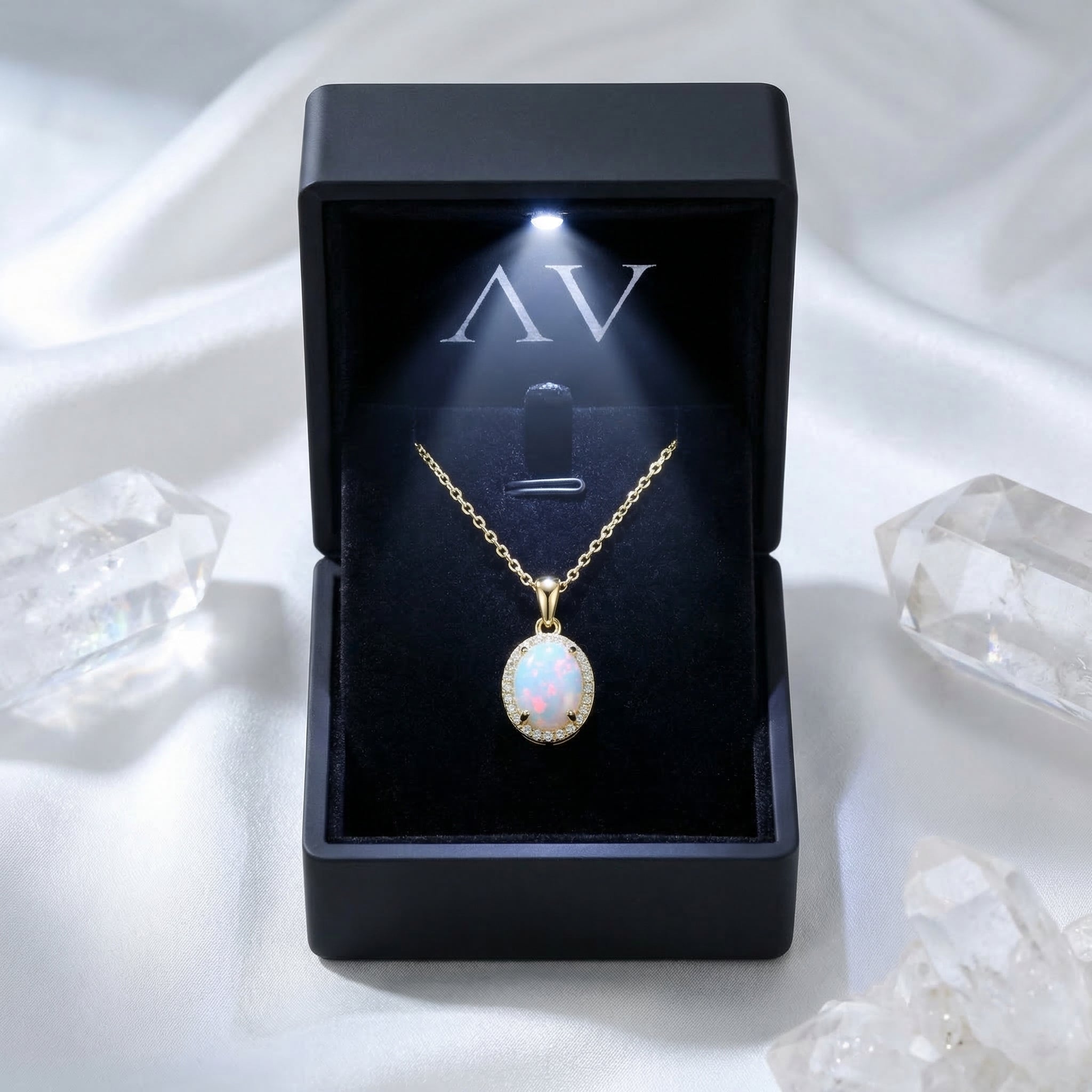 Gold-tone oval white opal necklace presented in a black LED-lit jewelry gift box on white silk.