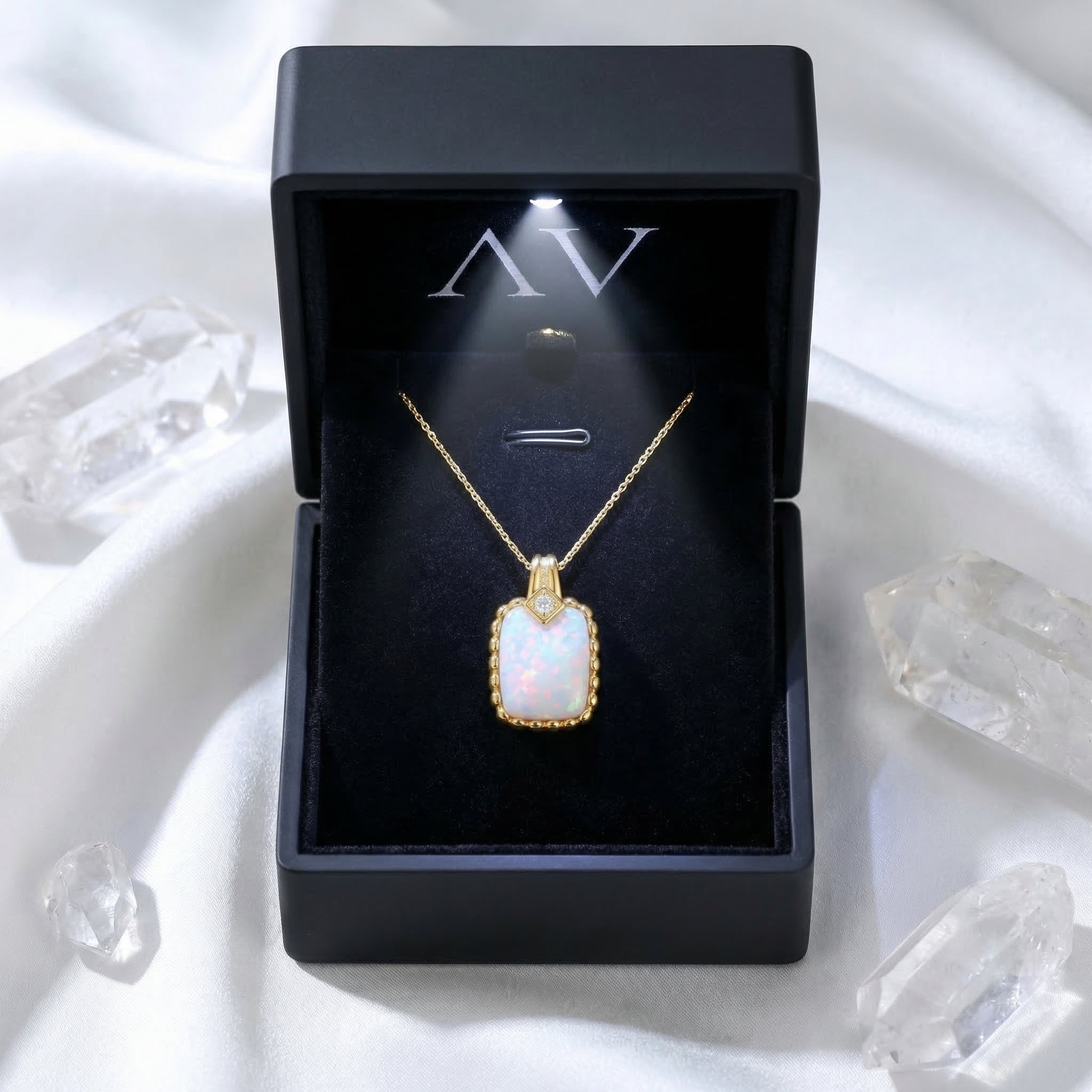 Gold cushion cut white opal pendant necklace presented in a black illuminated gift box.