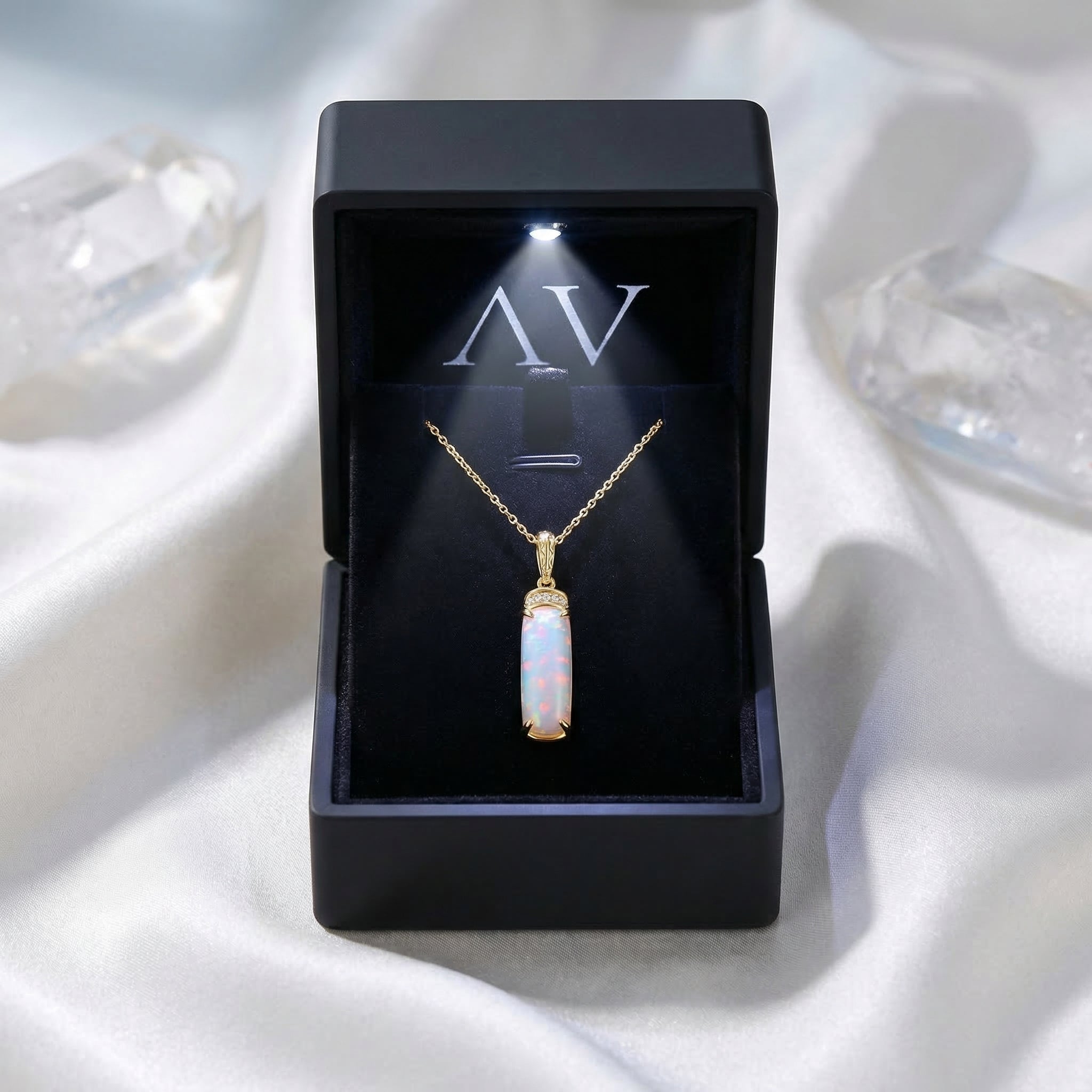 Gold-tone Galatea white opal column necklace presented in a black illuminated gift box on white silk.