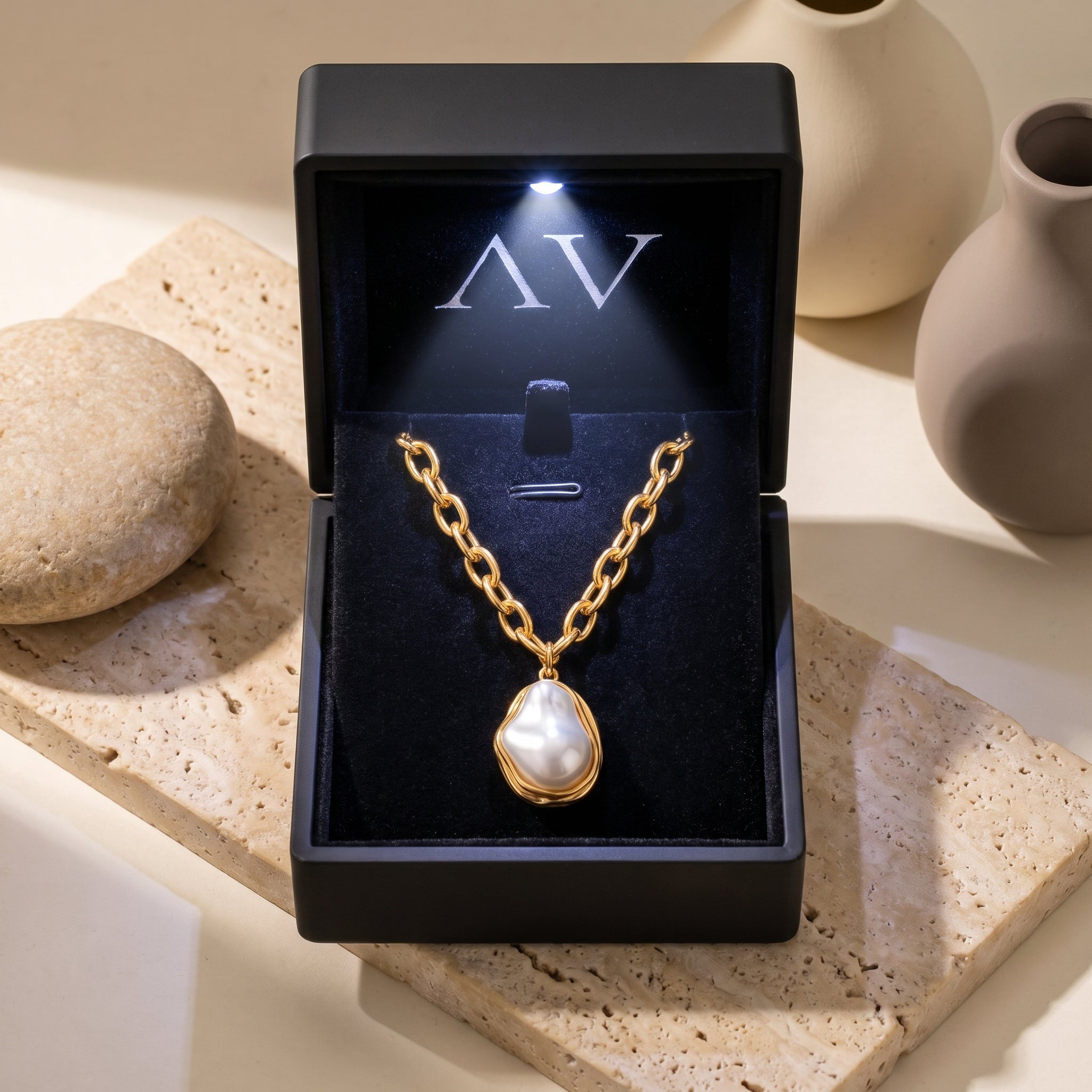 Gold Isabella pearl necklace presented in a black illuminated jewelry gift box.