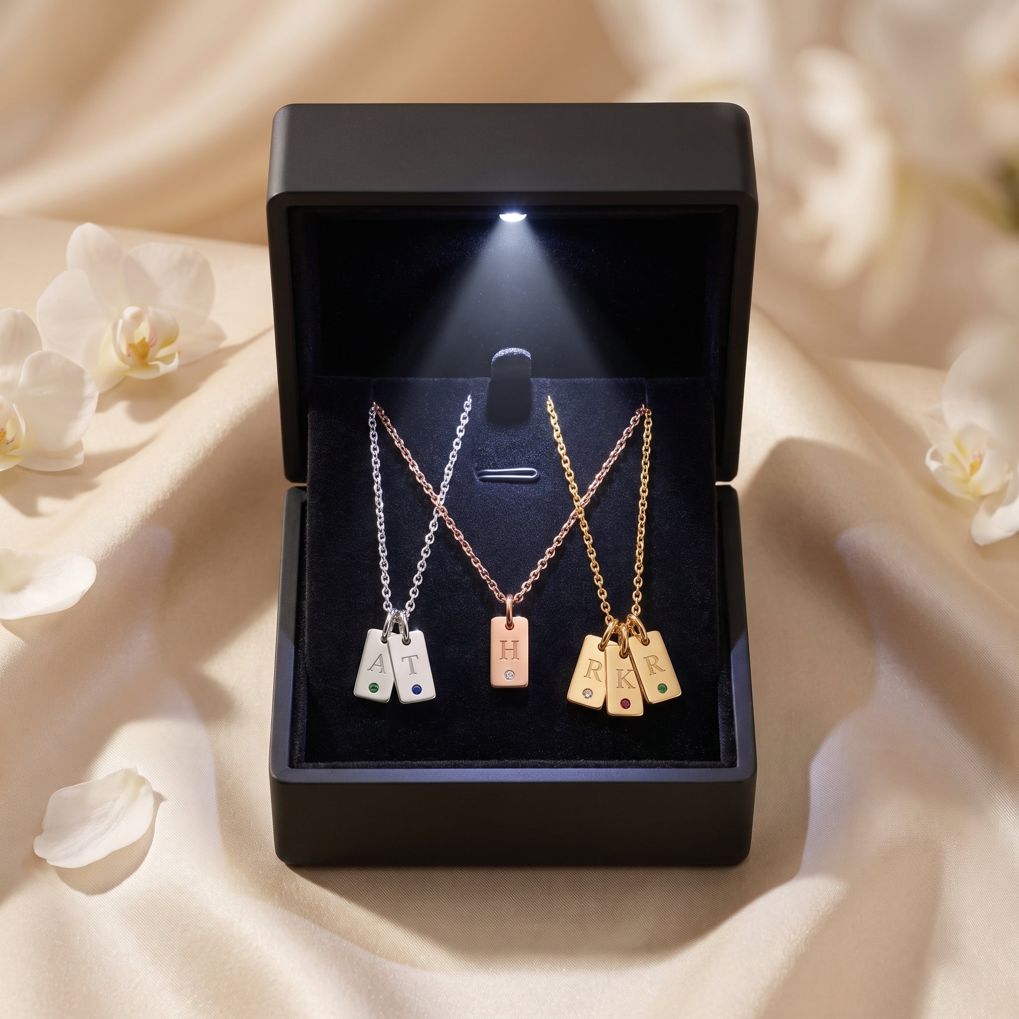Silver, rose gold, and gold Cecelia pendant necklaces displayed in a premium black LED-lit jewelry gift box.