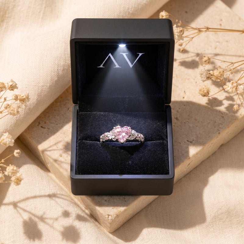 The Rosalique Ring, a solid gold ring with a heart-cut pink VVS Moissanite, presented in a lighted gift box.