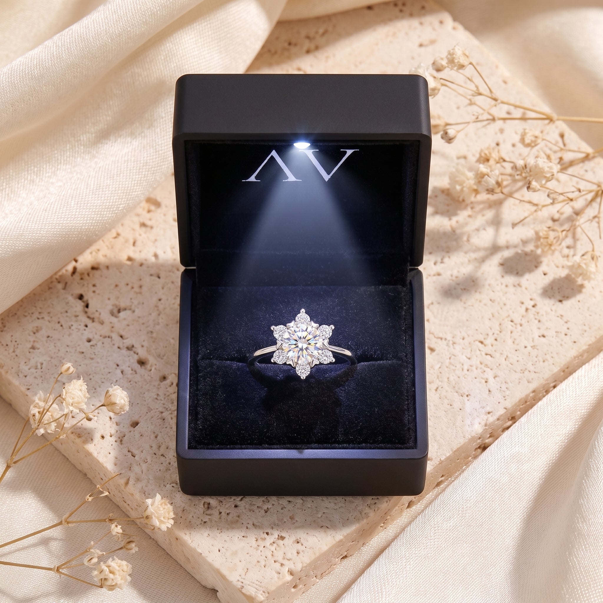 Sterling silver snowflake cluster ring inside a black LED-lit jewelry presentation box.