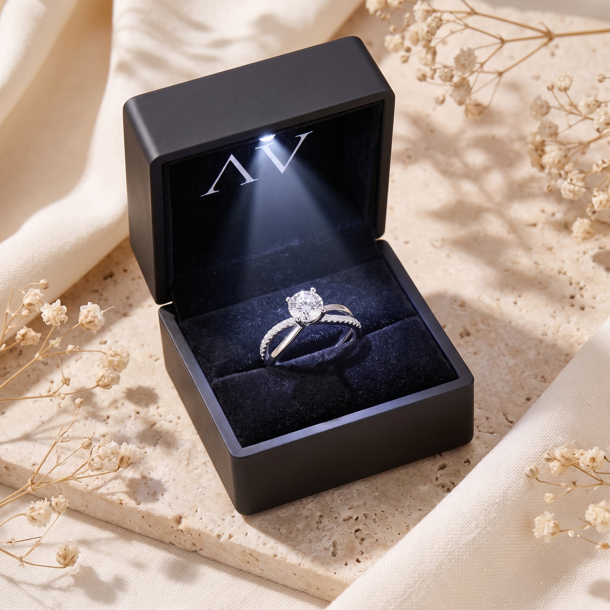Solitaire ring inside a black LED-lighted jewelry gift box.