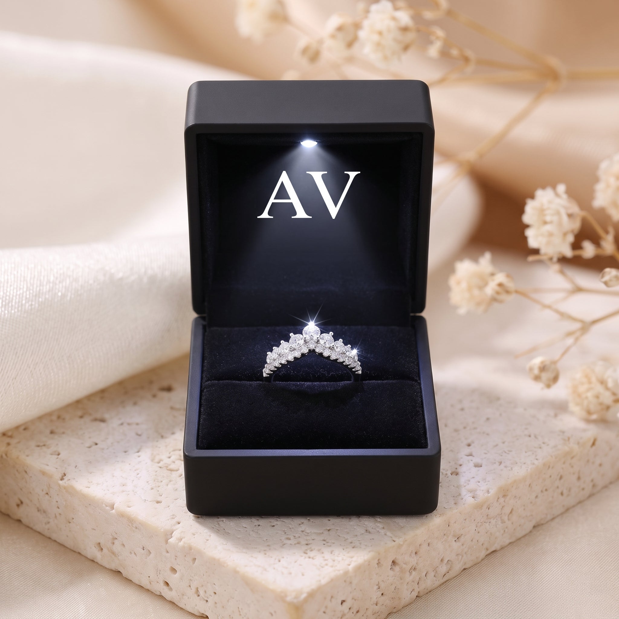 Silver chevron ring with cubic zirconia presented in a black LED-lit jewelry box with AV logo.