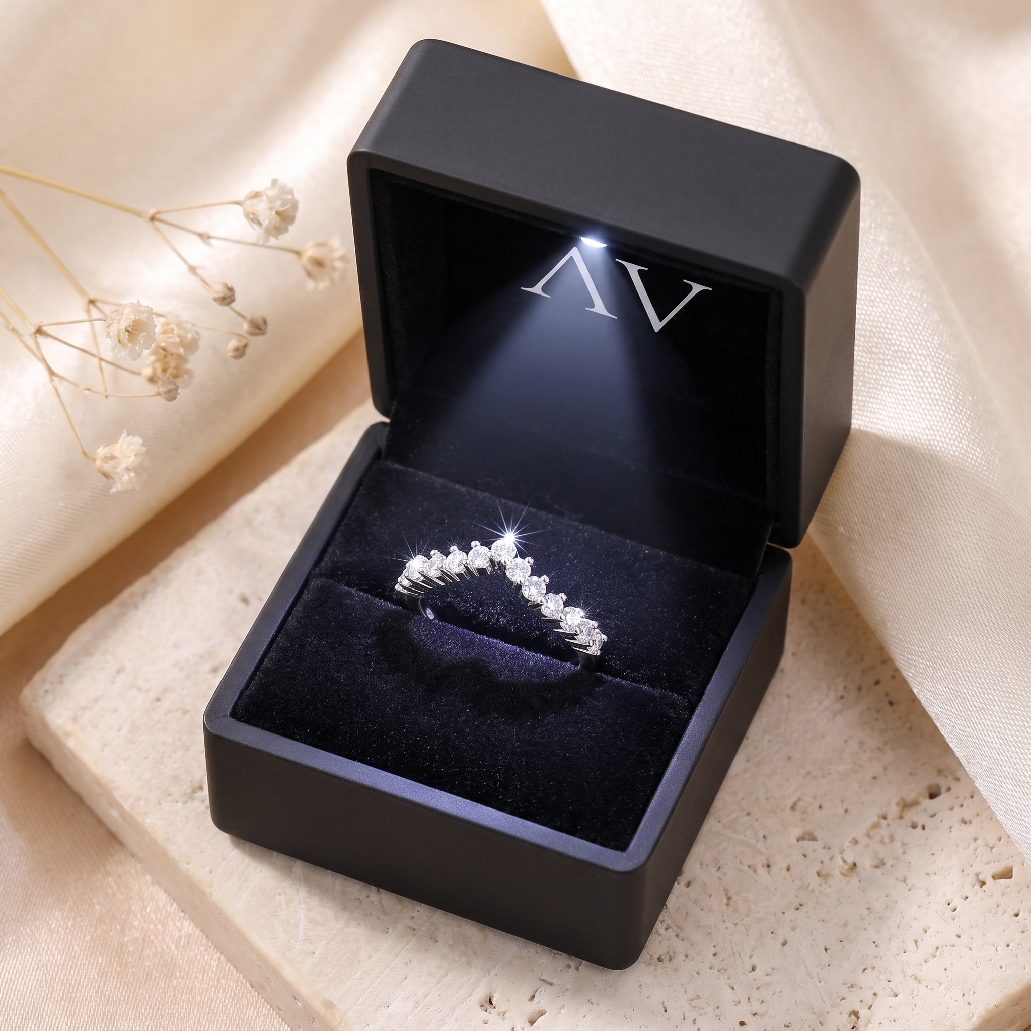 Silver chevron cubic zirconia ring inside a black LED-lit presentation box.