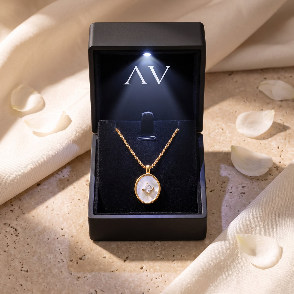 18K gold Lucelle necklace with mother of pearl pendant inside a premium black LED-lit jewelry box with AV logo.